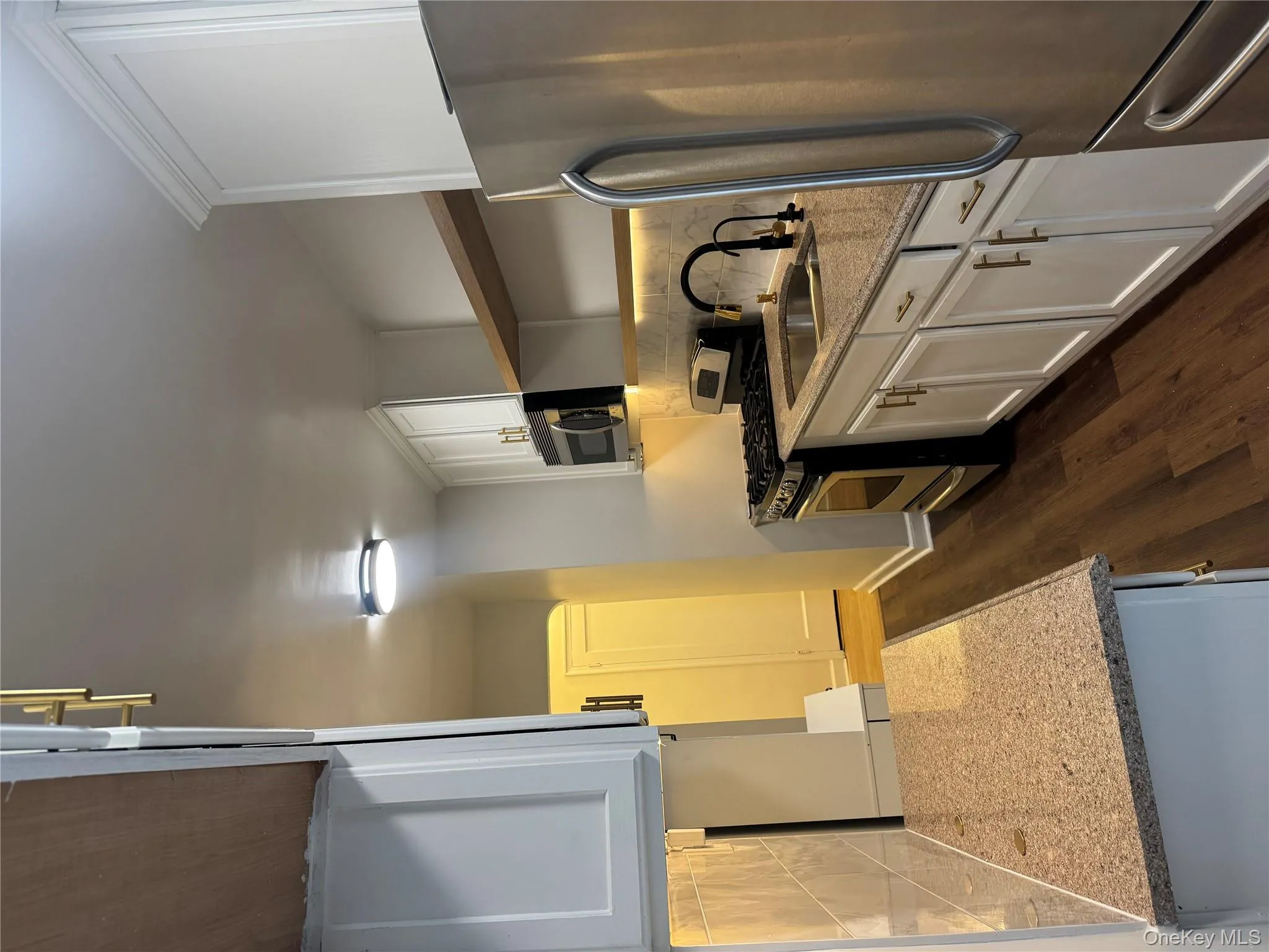 Kitchen with tasteful backsplash, open shelves, refrigerator, and white cabinetry Kitchen with tasteful backsplash, open shelves, refrigerator, and white cabinetry