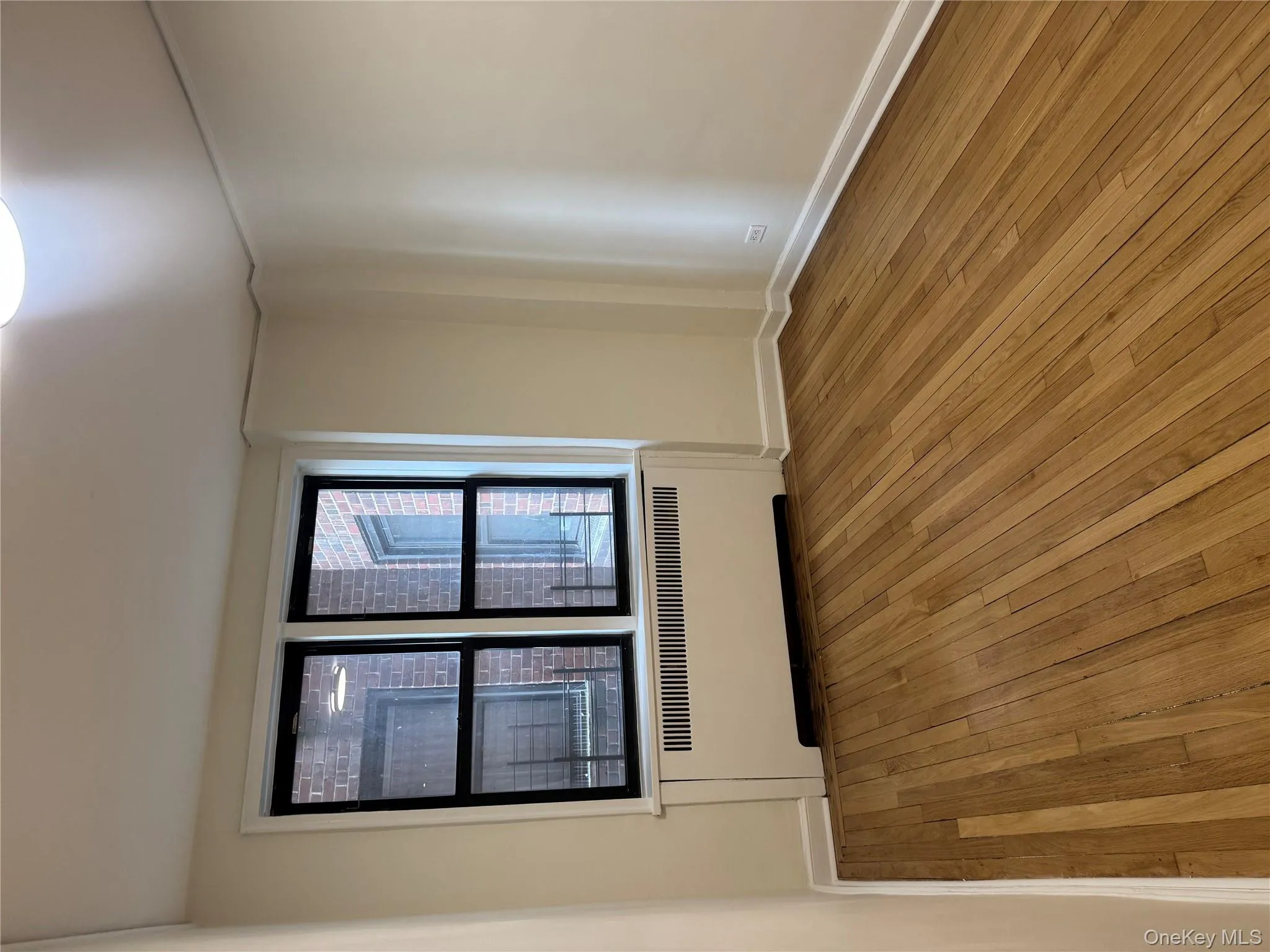 Empty room with radiator heating unit and hardwood / wood-style flooring Empty room with radiator heating unit and hardwood / wood-style flooring