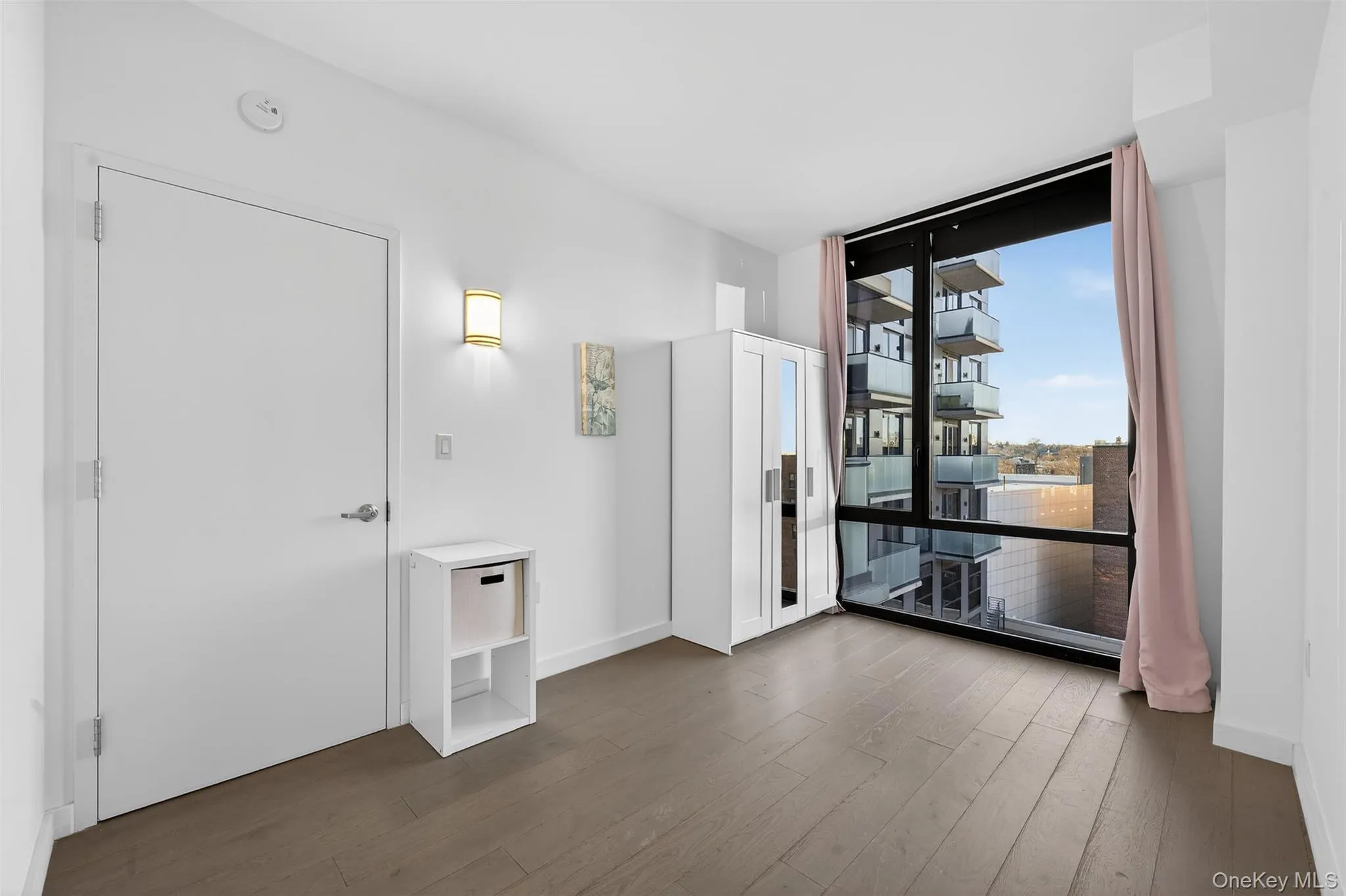Unfurnished room featuring floor to ceiling windows and hardwood / wood-style flooring Unfurnished room featuring floor to ceiling windows and hardwood / wood-style flooring
