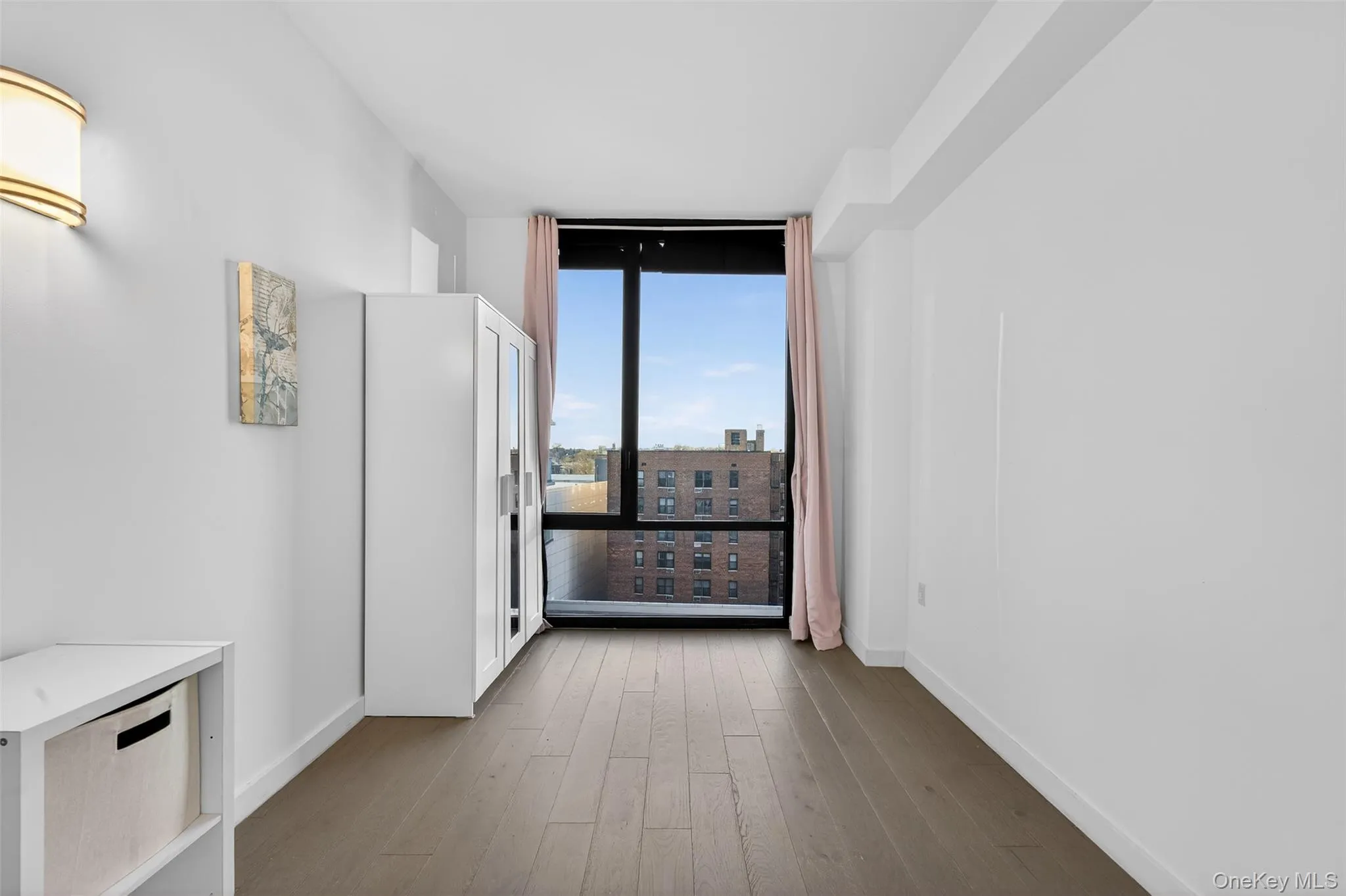 Spare room featuring floor to ceiling windows, hardwood / wood-style floors, and a city view Spare room featuring floor to ceiling windows, hardwood / wood-style floors, and a city view