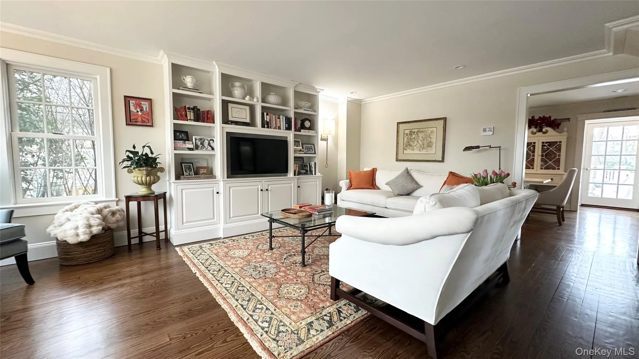 Living room featuring dark hardwood / wood-style flooring and ornamental molding Living room featuring dark hardwood / wood-style flooring and ornamental molding