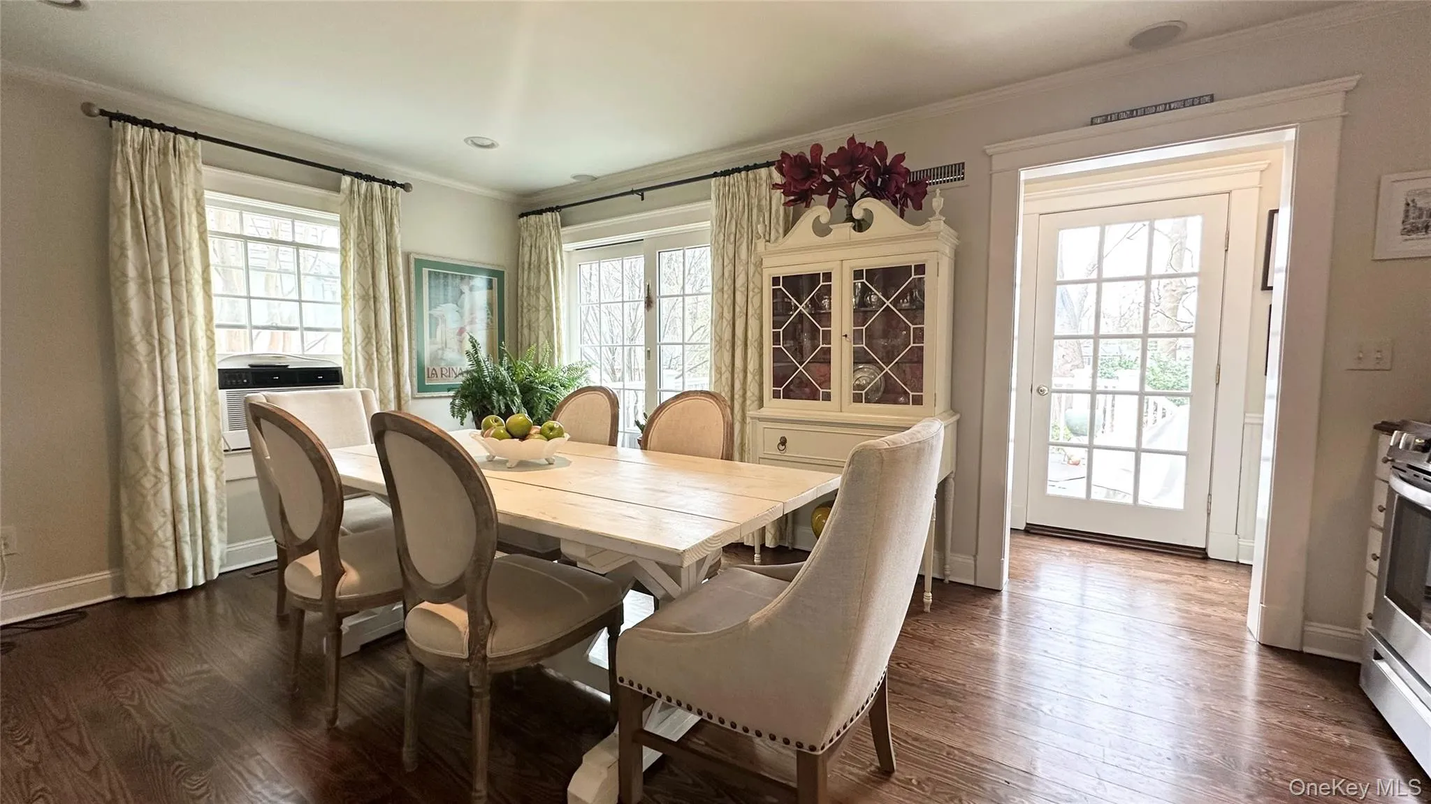 Dining space featuring crown molding, plenty of natural light, and dark hardwood / wood-style floors Dining space featuring crown molding, plenty of natural light, and dark hardwood / wood-style floors