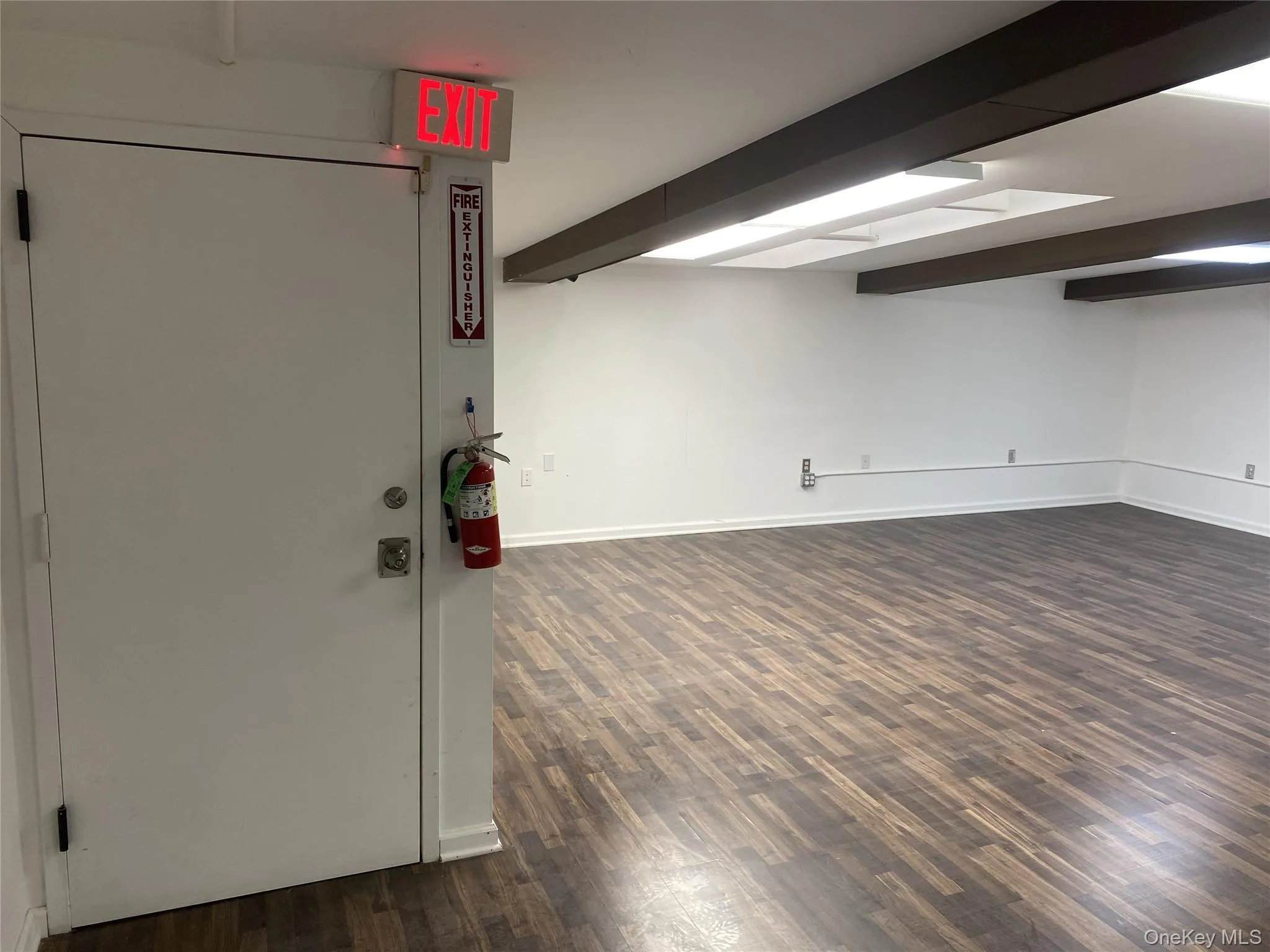 Finished below grade area with dark wood-type flooring and baseboards Finished below grade area with dark wood-type flooring and baseboards