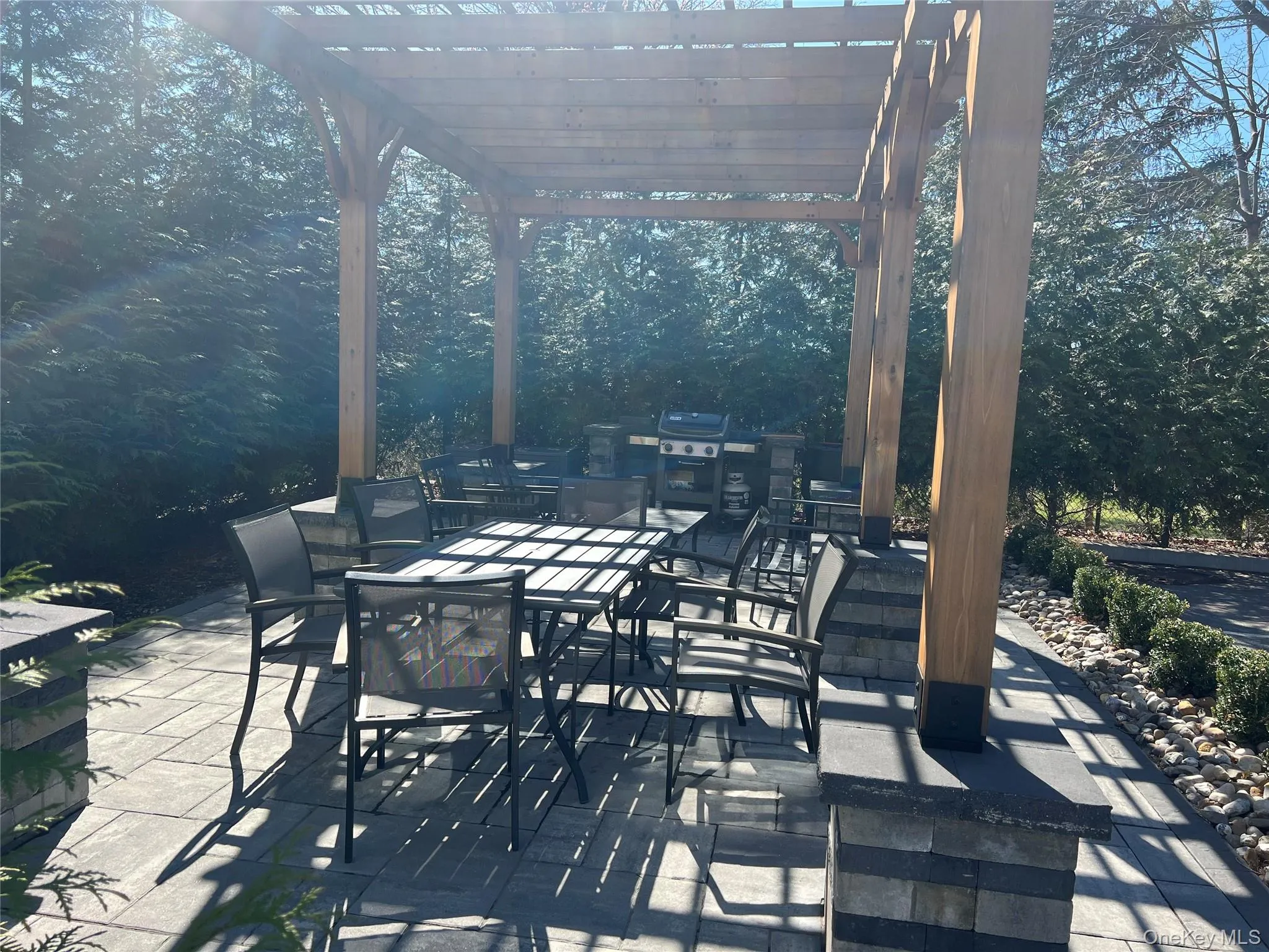 View of patio with a pergola, outdoor dining space, and view of wooded area View of patio with a pergola, outdoor dining space, and view of wooded area