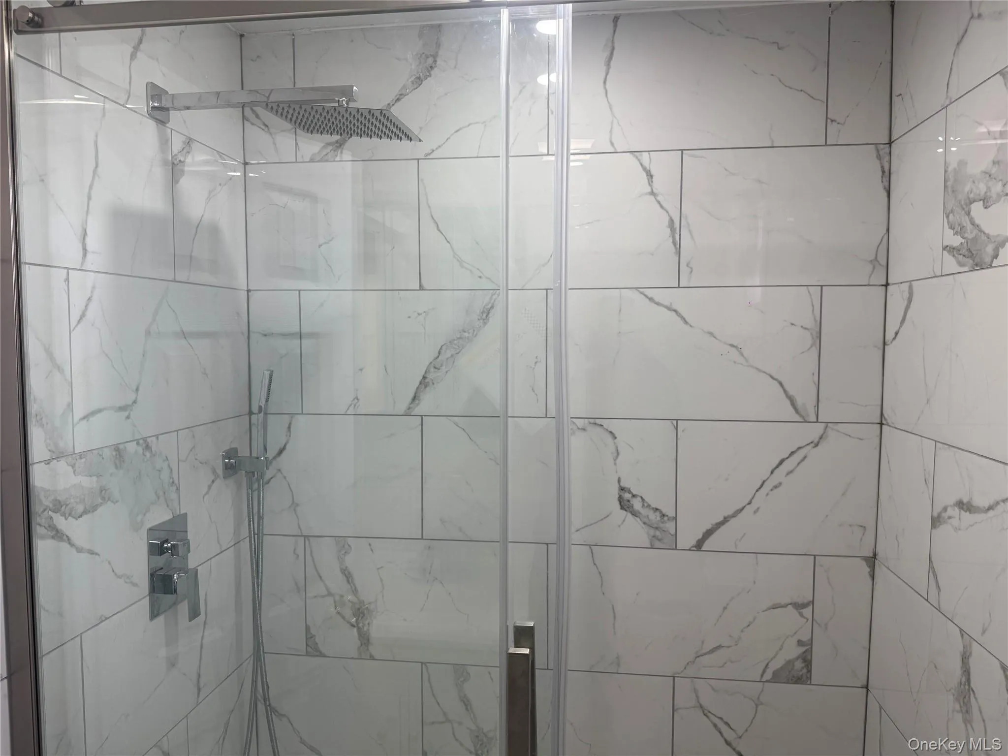 Full bathroom with a marble finish shower Full bathroom with a marble finish shower