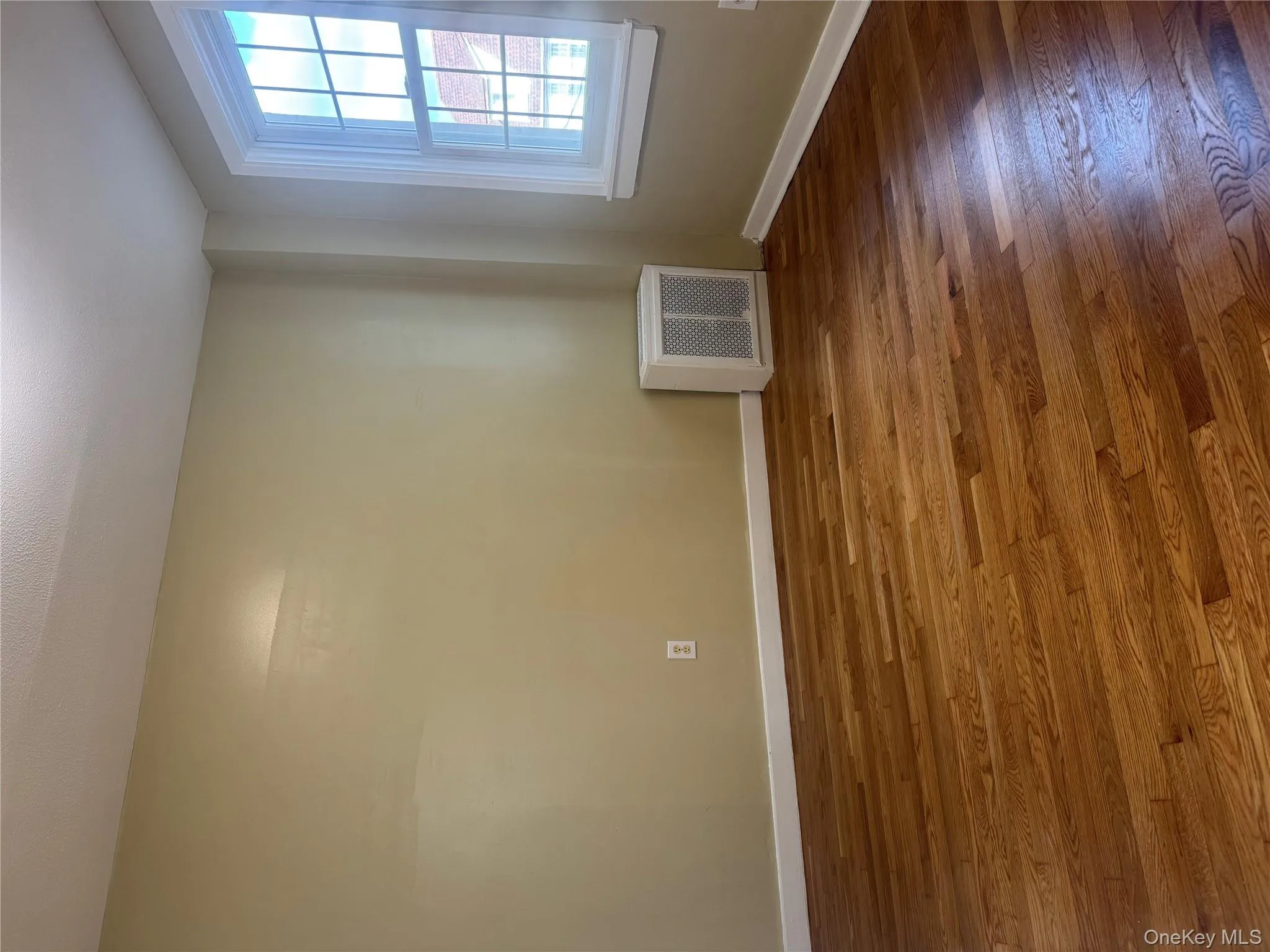 Unfurnished room featuring wood-type flooring and radiator heating unit Unfurnished room featuring wood-type flooring and radiator heating unit