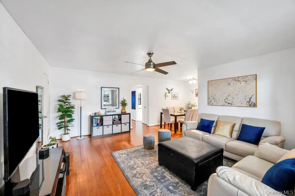 Living area featuring ceiling fan and hardwood / wood-style flooring Living area featuring ceiling fan and hardwood / wood-style flooring