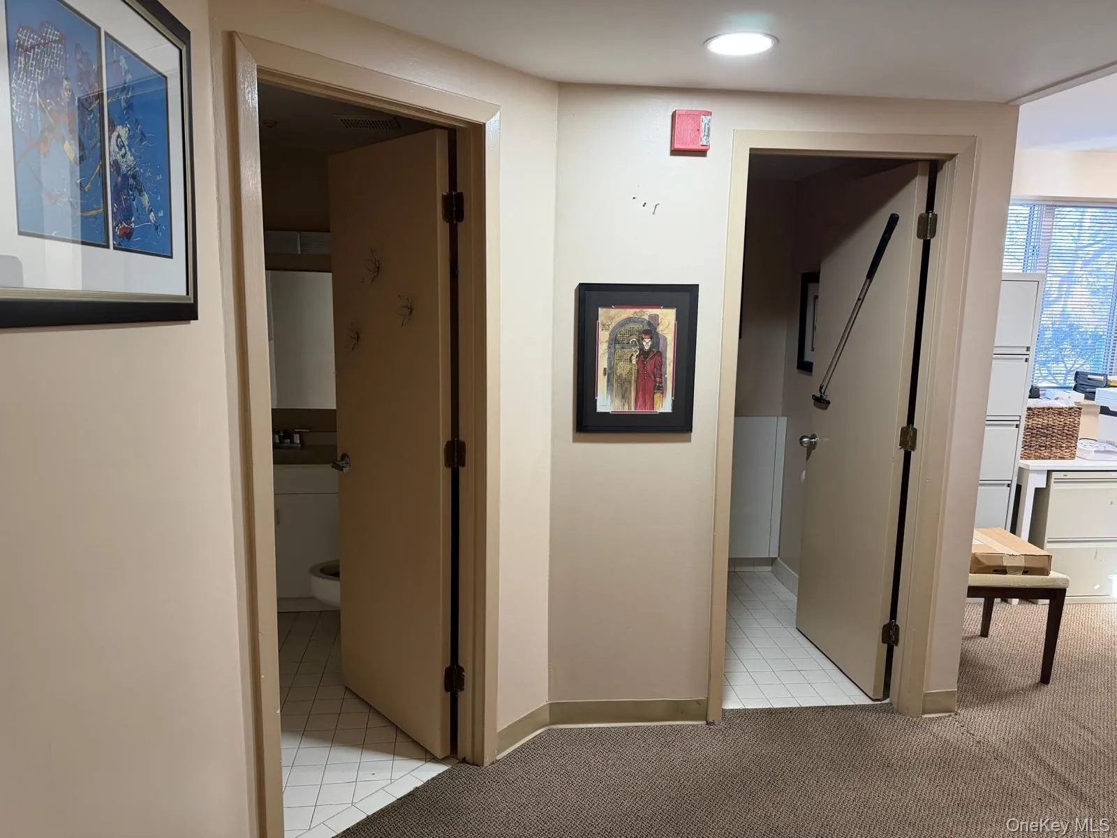 Hall featuring light tile patterned flooring and light colored carpet Hall featuring light tile patterned flooring and light colored carpet