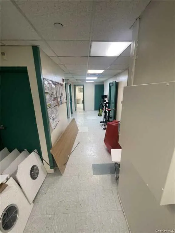 Hallway with light floors and a paneled ceiling Hallway with light floors and a paneled ceiling