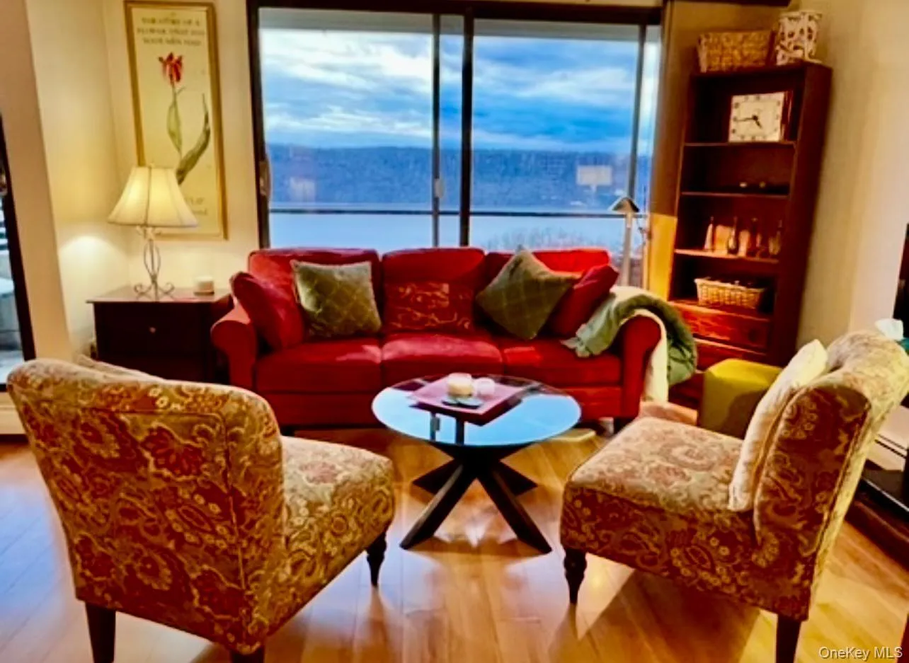 Living area with wood finished floors and a water view Living area with wood finished floors and a water view