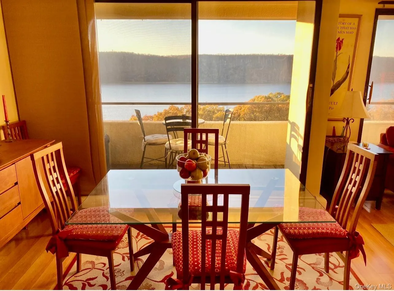 Dining space with light wood-type flooring and a water view Dining space with light wood-type flooring and a water view