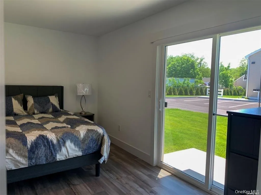 Bedroom featuring access to exterior and dark wood-type flooring Bedroom featuring access to exterior and dark wood-type flooring