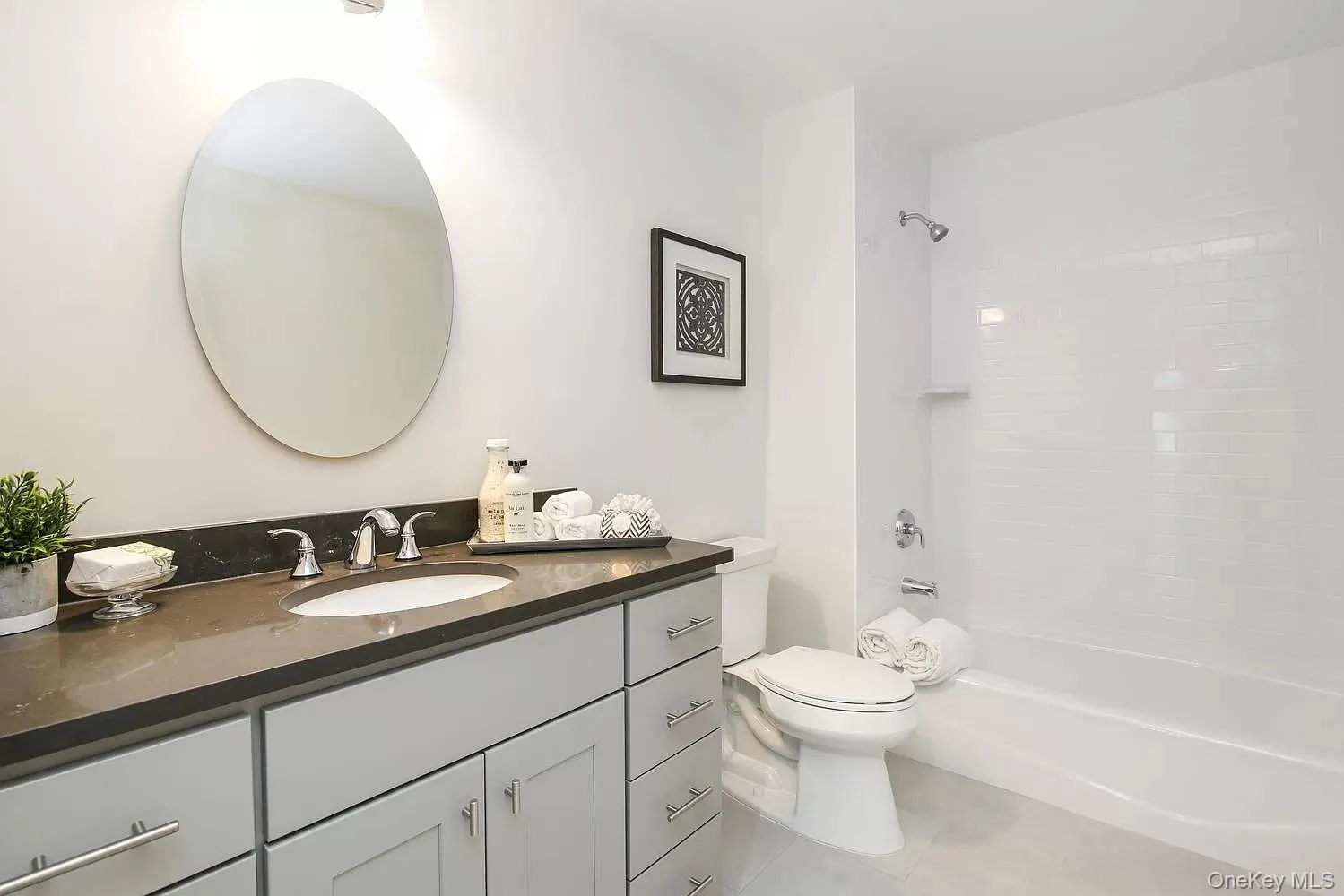Bathroom featuring vanity, shower / bath combination, and light tile patterned floors Bathroom featuring vanity, shower / bath combination, and light tile patterned floors