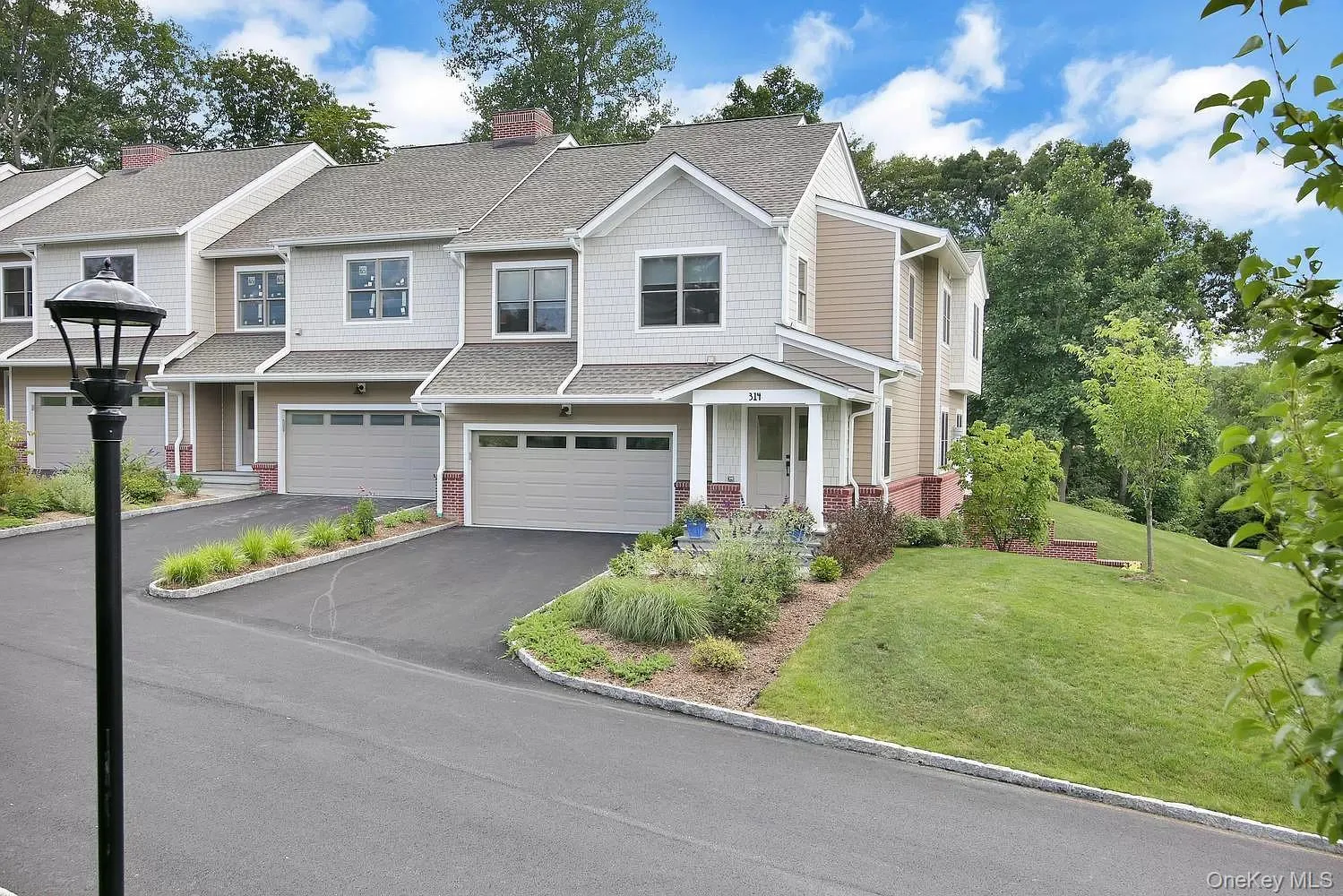 Craftsman house with driveway, a shingled roof, a front lawn, brick siding, and a chimney Craftsman house with driveway, a shingled roof, a front lawn, brick siding, and a chimney