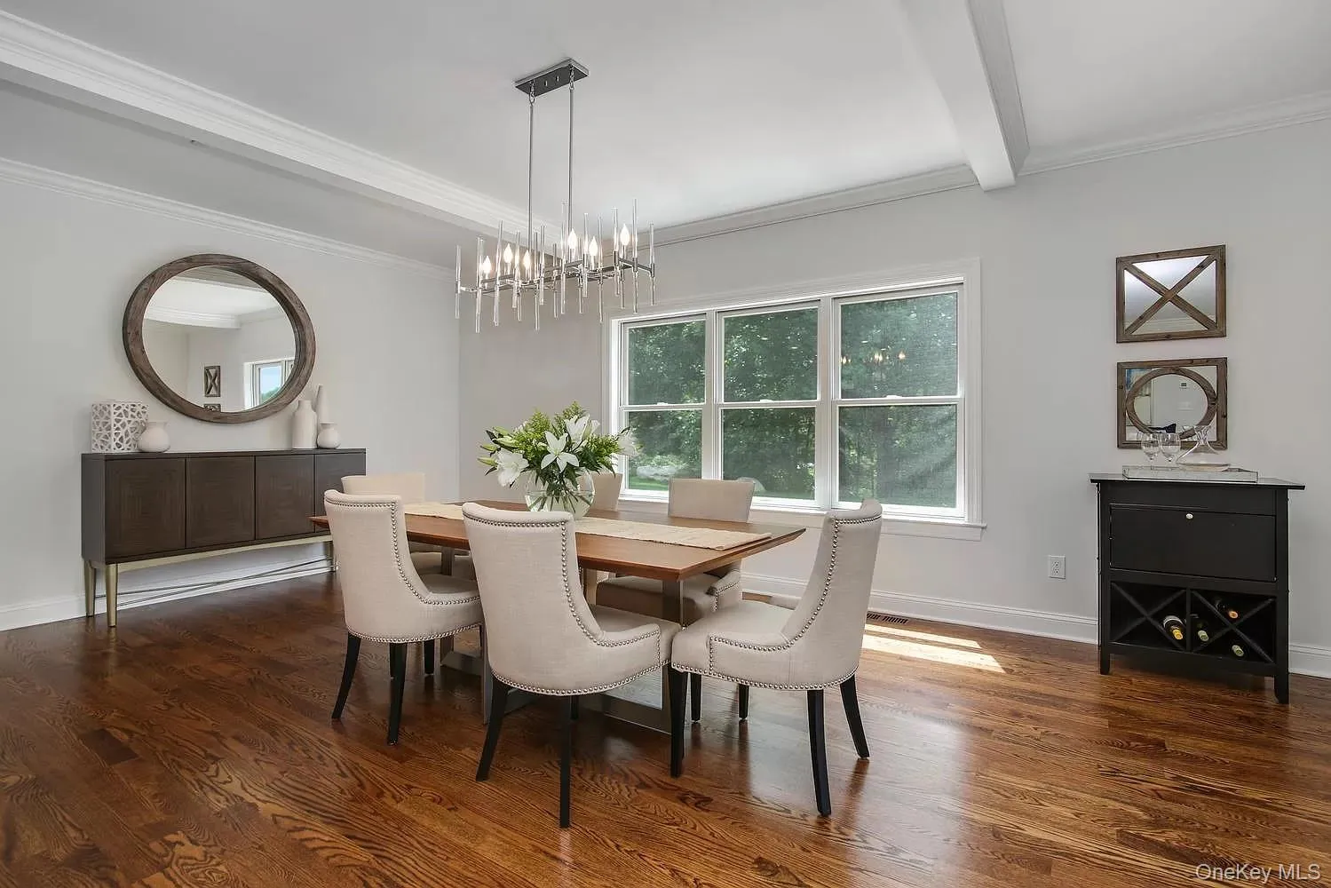 Dining space with dark wood finished floors, crown molding, a chandelier, and beam ceiling Dining space with dark wood finished floors, crown molding, a chandelier, and beam ceiling