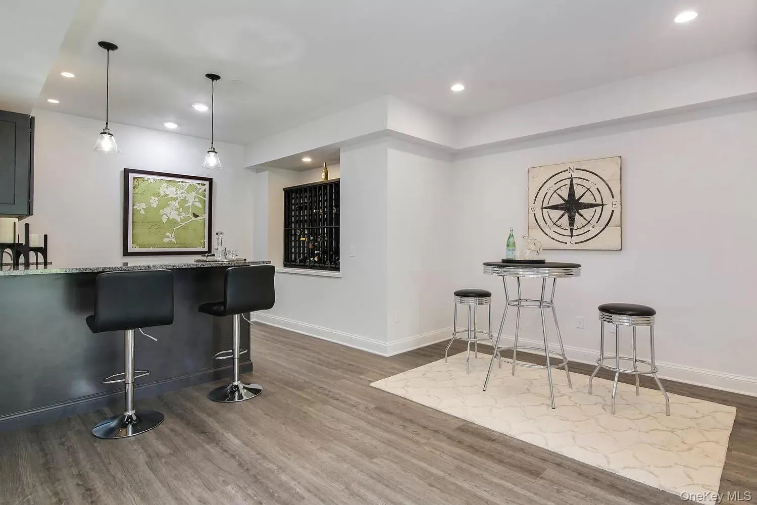 Indoor wet bar with decorative light fixtures, light stone countertops, dark wood-style floors, and recessed lighting Indoor wet bar with decorative light fixtures, light stone countertops, dark wood-style floors, and recessed lighting