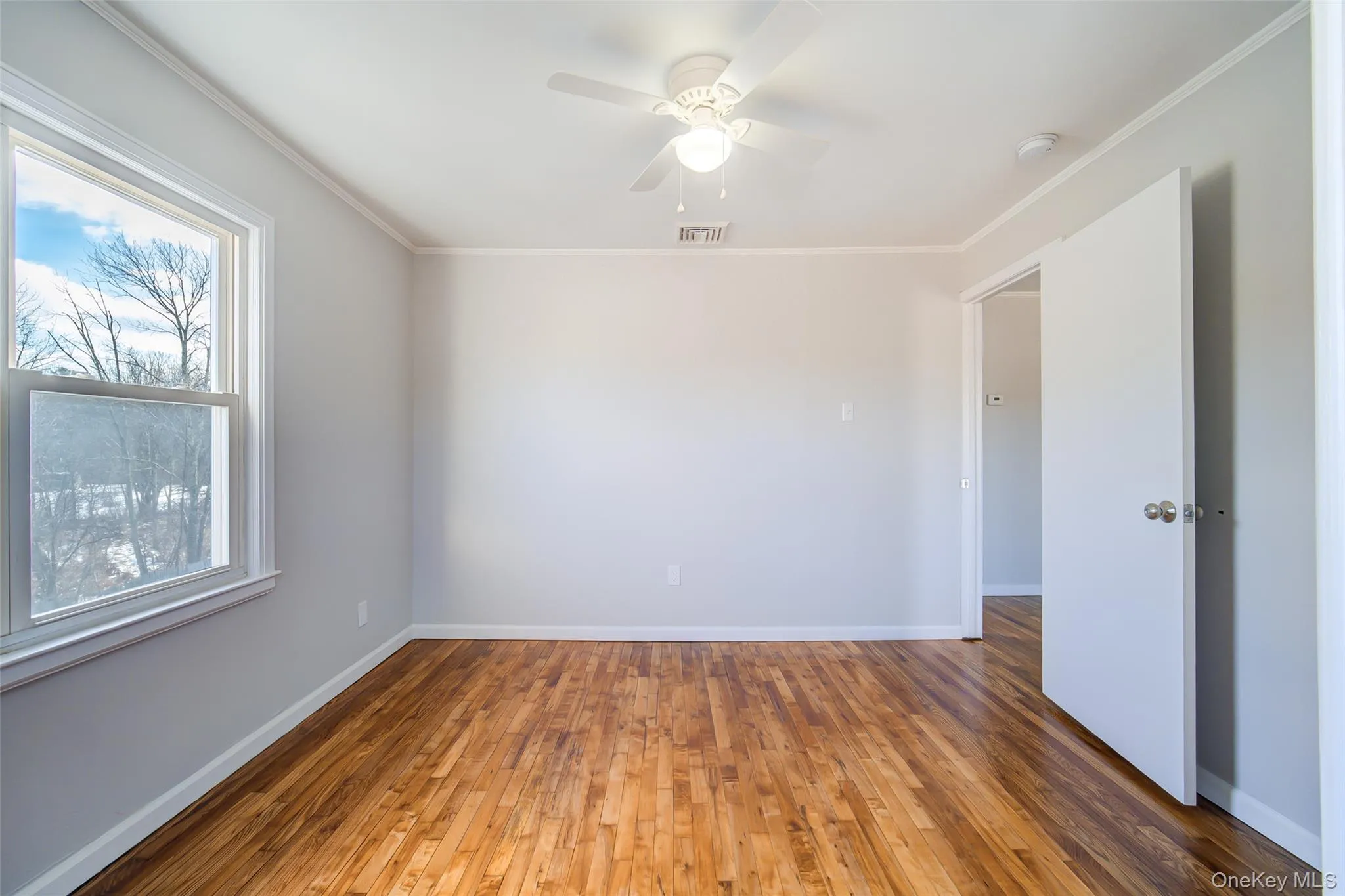 Bedroom featuring crown molding, hardwood / wood-style flooring, and a ceiling fan Bedroom featuring crown molding, hardwood / wood-style flooring, and a ceiling fan