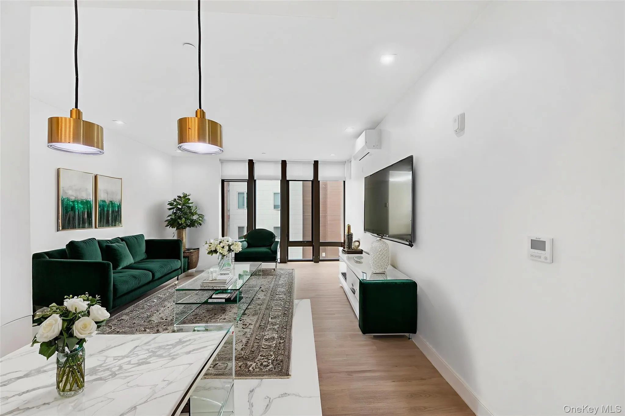 Living room with light wood-style flooring, a wall of windows, and a wall unit AC Living room with light wood-style flooring, a wall of windows, and a wall unit AC