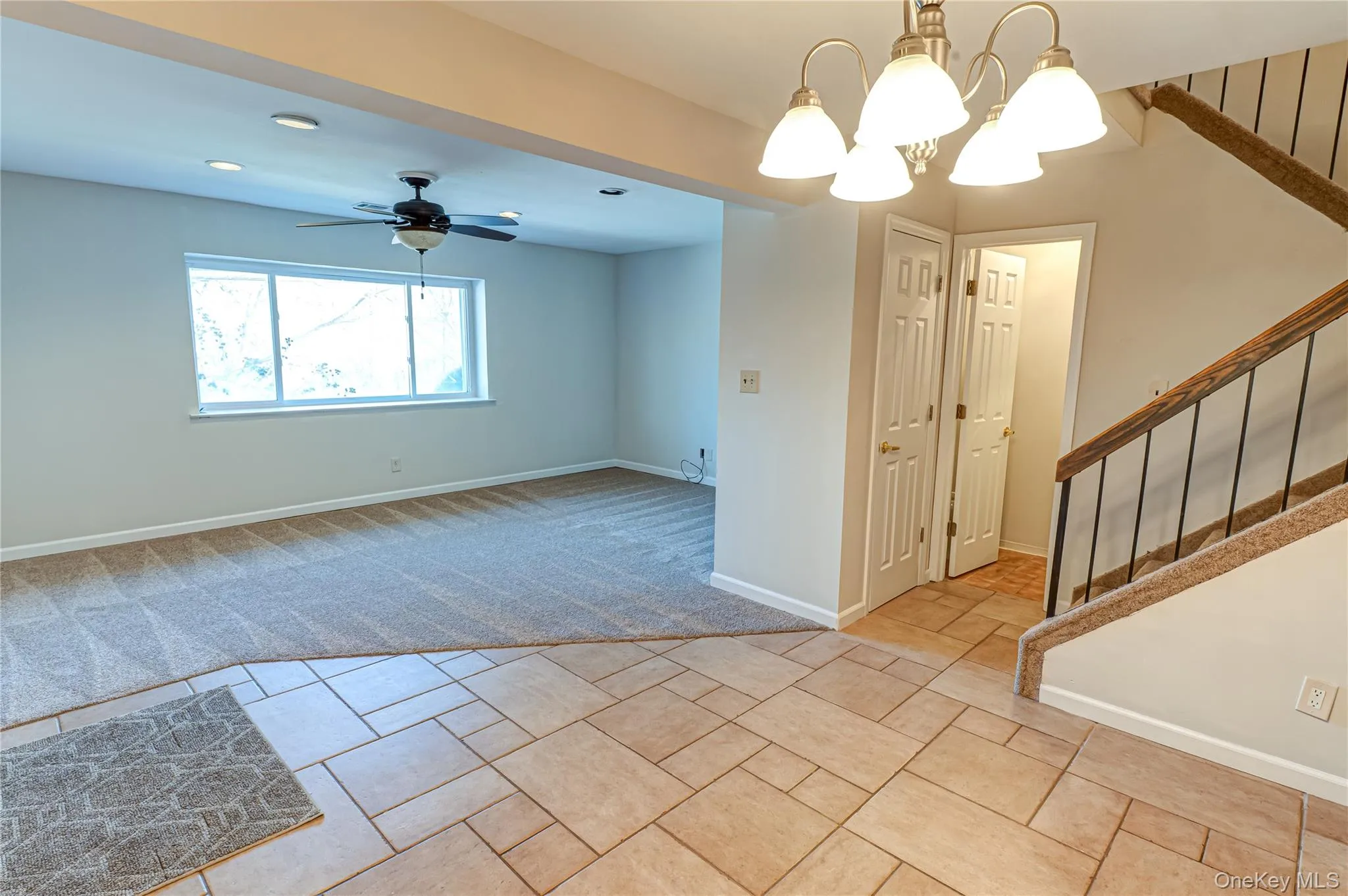 Spare room featuring stairway, light carpet, a chandelier, recessed lighting, and a ceiling fan Spare room featuring stairway, light carpet, a chandelier, recessed lighting, and a ceiling fan