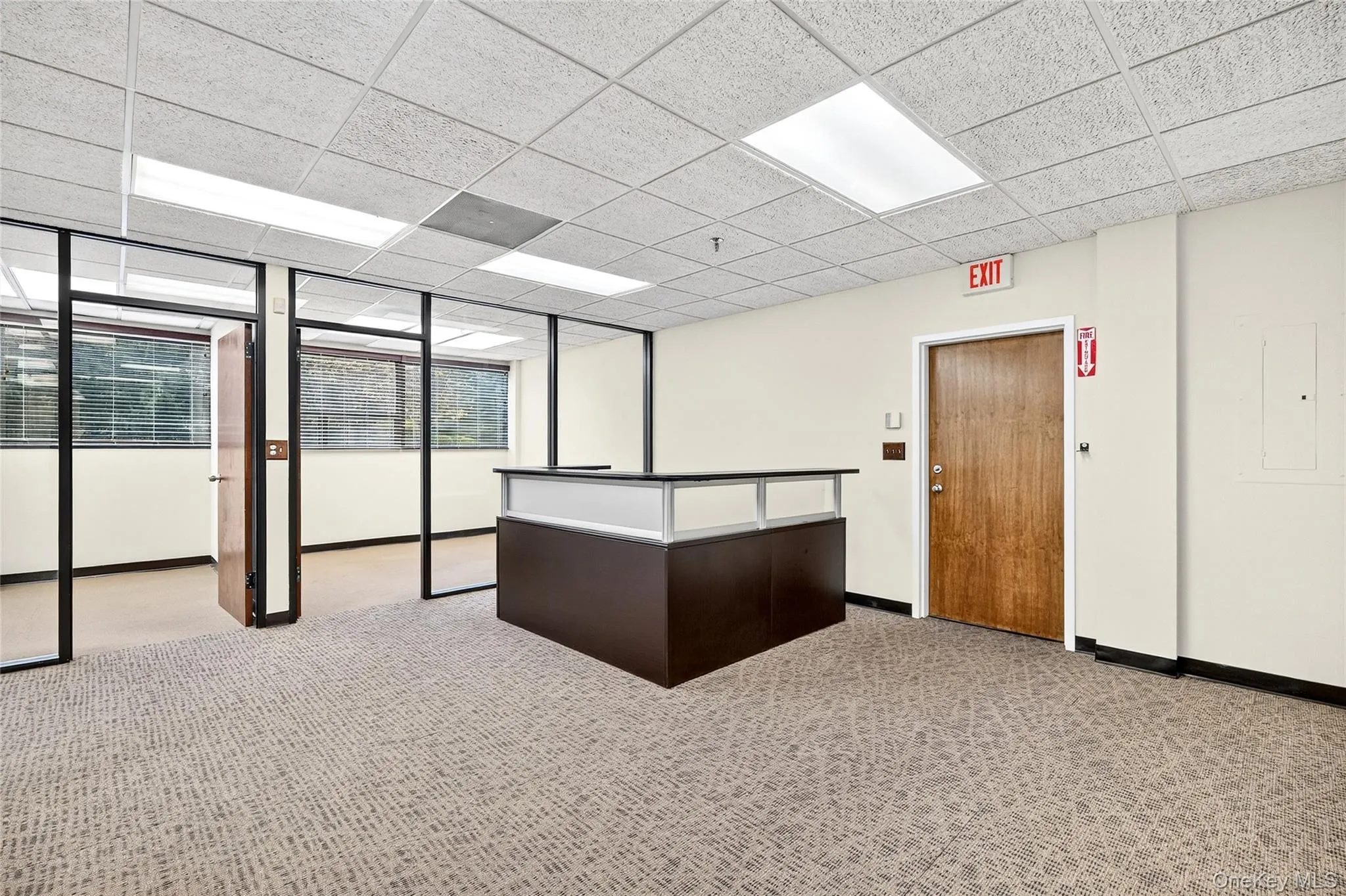 Reception area featuring a drop ceiling, electric panel, and floor to ceiling windows Reception area featuring a drop ceiling, electric panel, and floor to ceiling windows