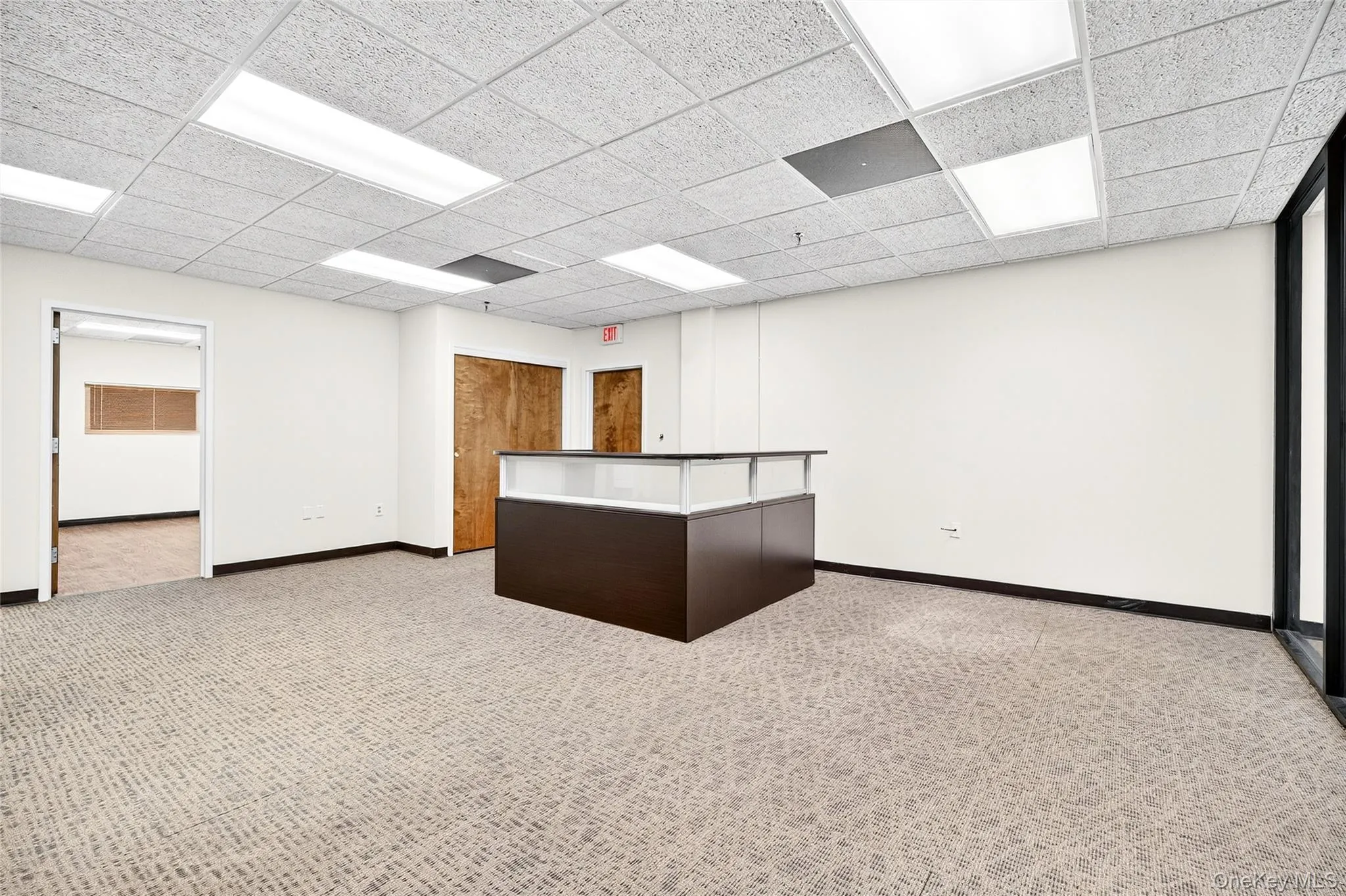 Empty room featuring light colored carpet and a paneled ceiling Empty room featuring light colored carpet and a paneled ceiling