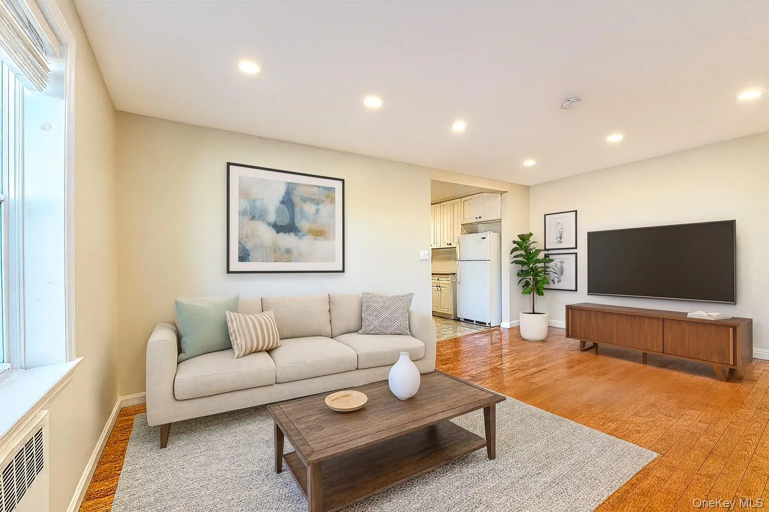 Living room featuring light wood-type flooring, recessed lighting, and radiator Living room featuring light wood-type flooring, recessed lighting, and radiator