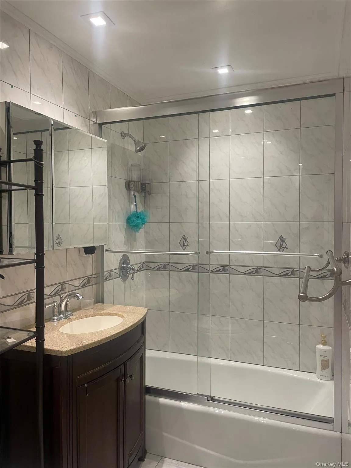 Full bathroom with vanity, enclosed tub / shower combo, and tile walls Full bathroom with vanity, enclosed tub / shower combo, and tile walls