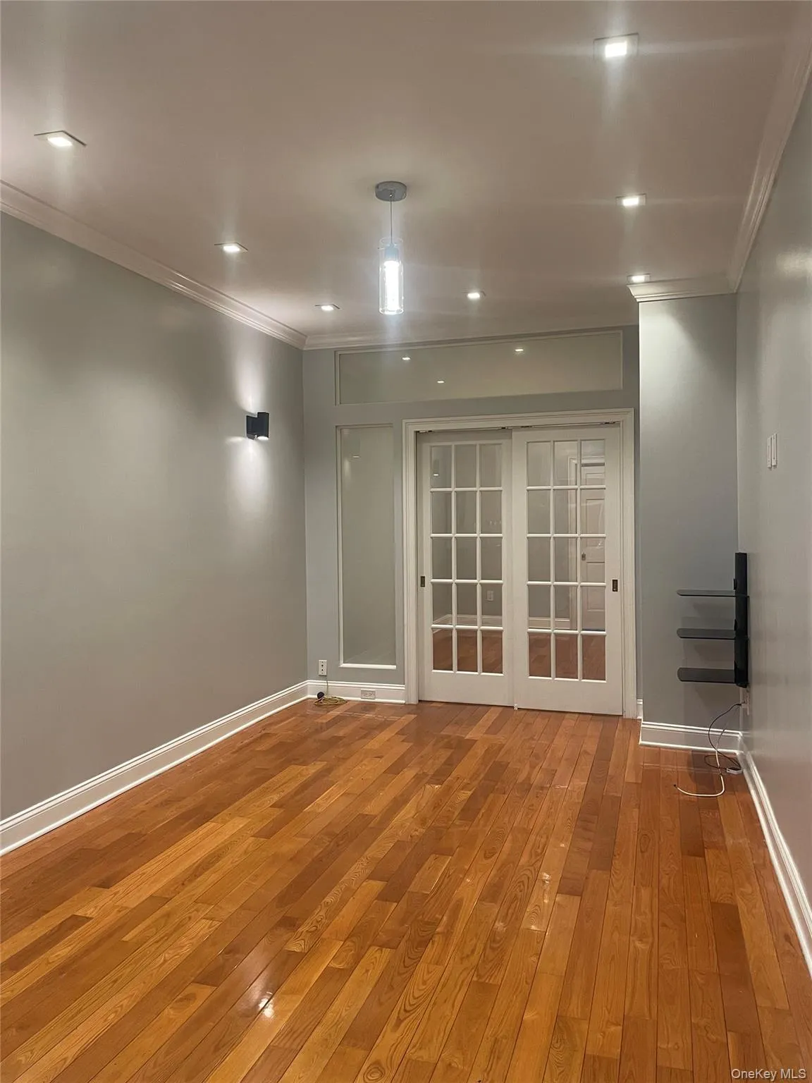 Empty room with crown molding, light wood-style flooring, and recessed lighting Empty room with crown molding, light wood-style flooring, and recessed lighting