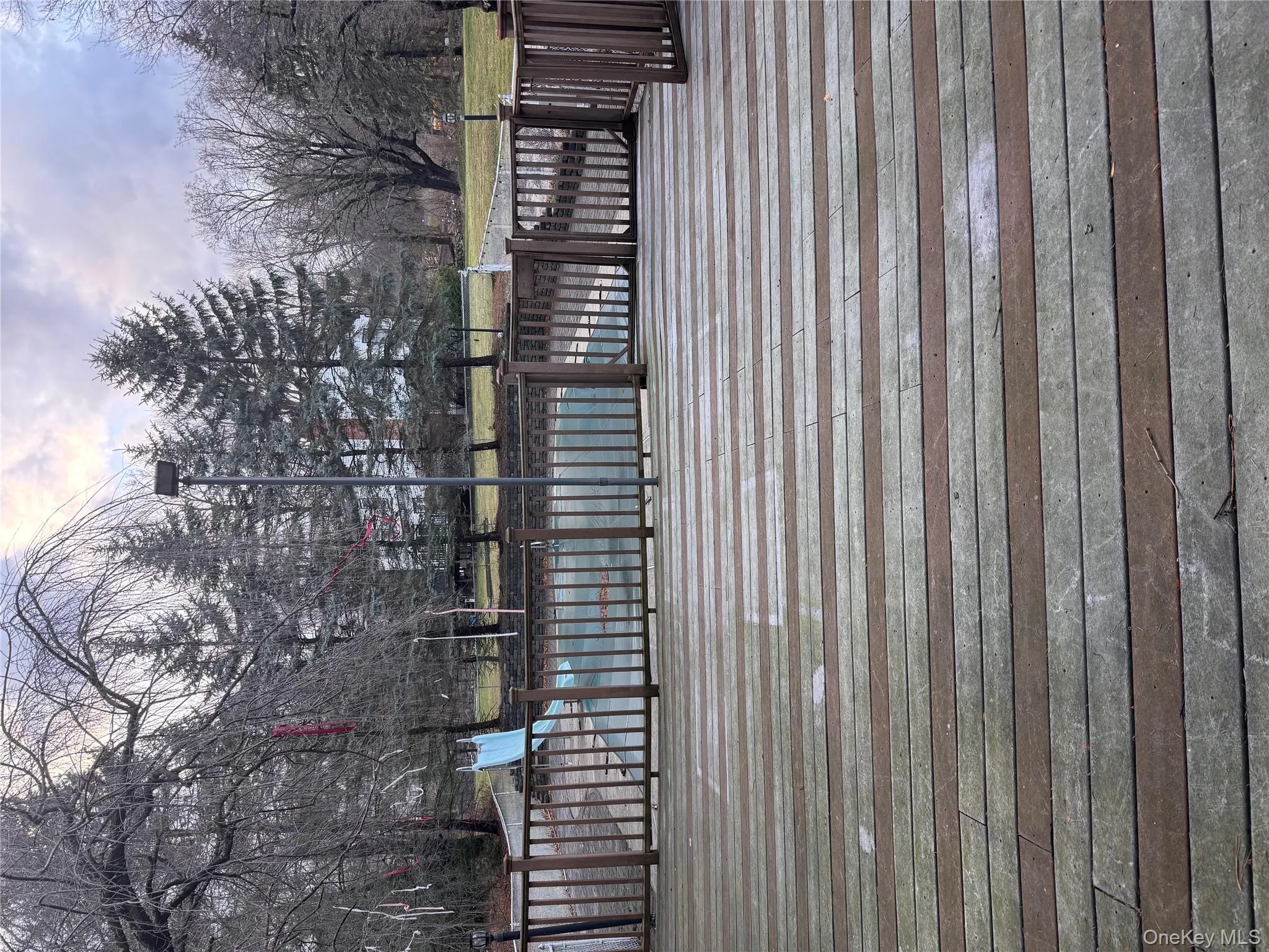 Wooden terrace with a covered pool and view of wooded area Wooden terrace with a covered pool and view of wooded area