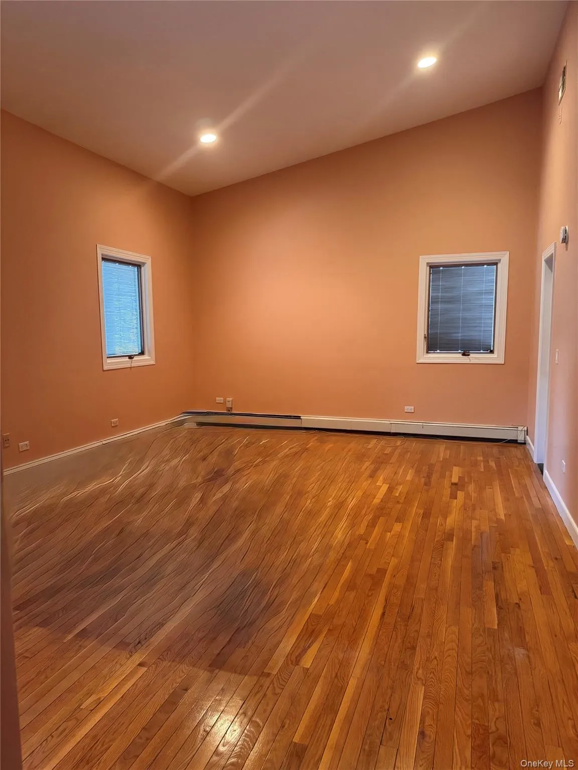 Unfurnished room featuring hardwood / wood-style flooring, recessed lighting, and baseboard heating Unfurnished room featuring hardwood / wood-style flooring, recessed lighting, and baseboard heating