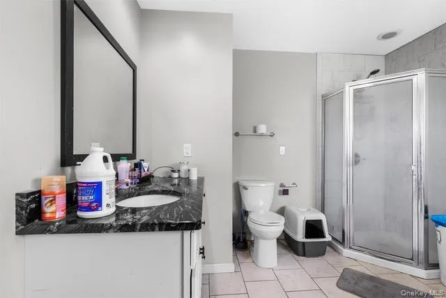Full bathroom with vanity, a stall shower, and light tile patterned flooring Full bathroom with vanity, a stall shower, and light tile patterned flooring