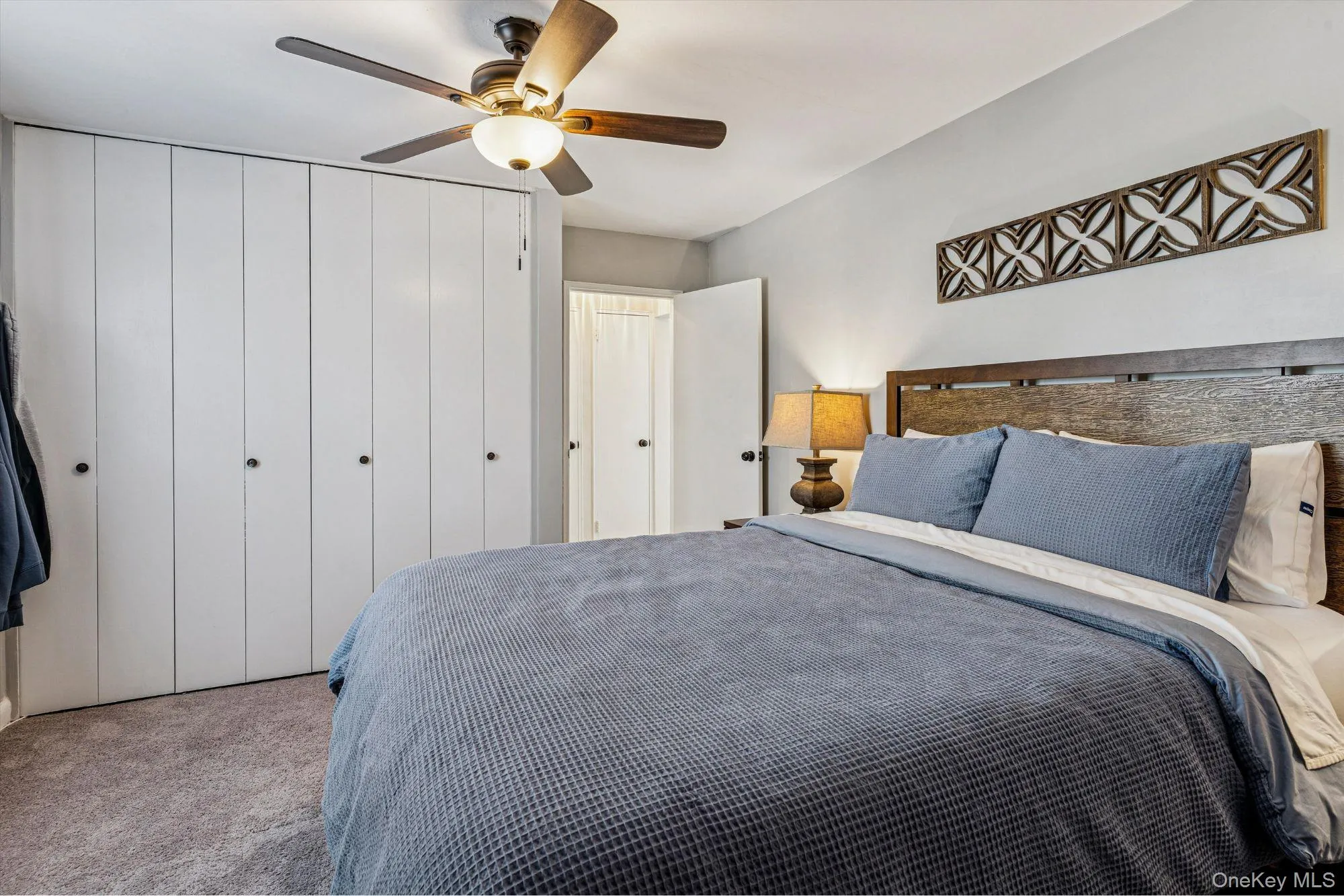 Carpeted bedroom with a closet and ceiling fan Carpeted bedroom with a closet and ceiling fan