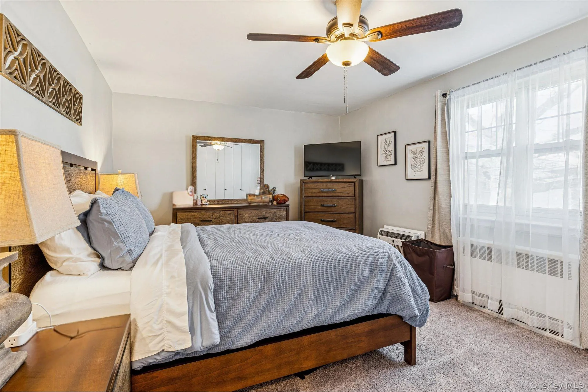 Carpeted bedroom featuring radiator heating unit and ceiling fan Carpeted bedroom featuring radiator heating unit and ceiling fan