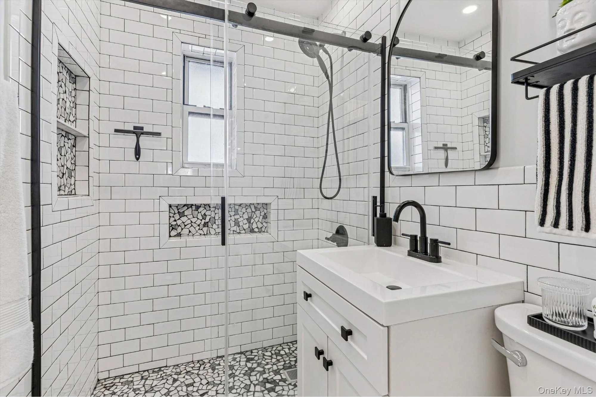 Full bathroom featuring vanity, a shower stall, decorative backsplash, and tile walls Full bathroom featuring vanity, a shower stall, decorative backsplash, and tile walls