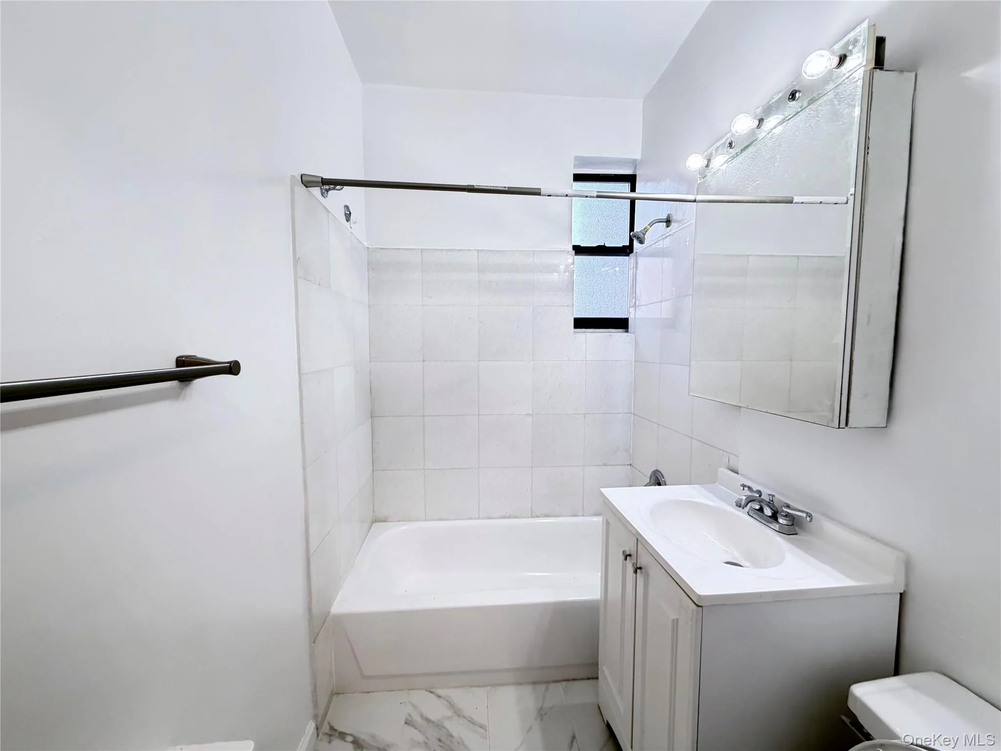 Bathroom with vanity, shower / washtub combination, and light marble finish flooring Bathroom with vanity, shower / washtub combination, and light marble finish flooring