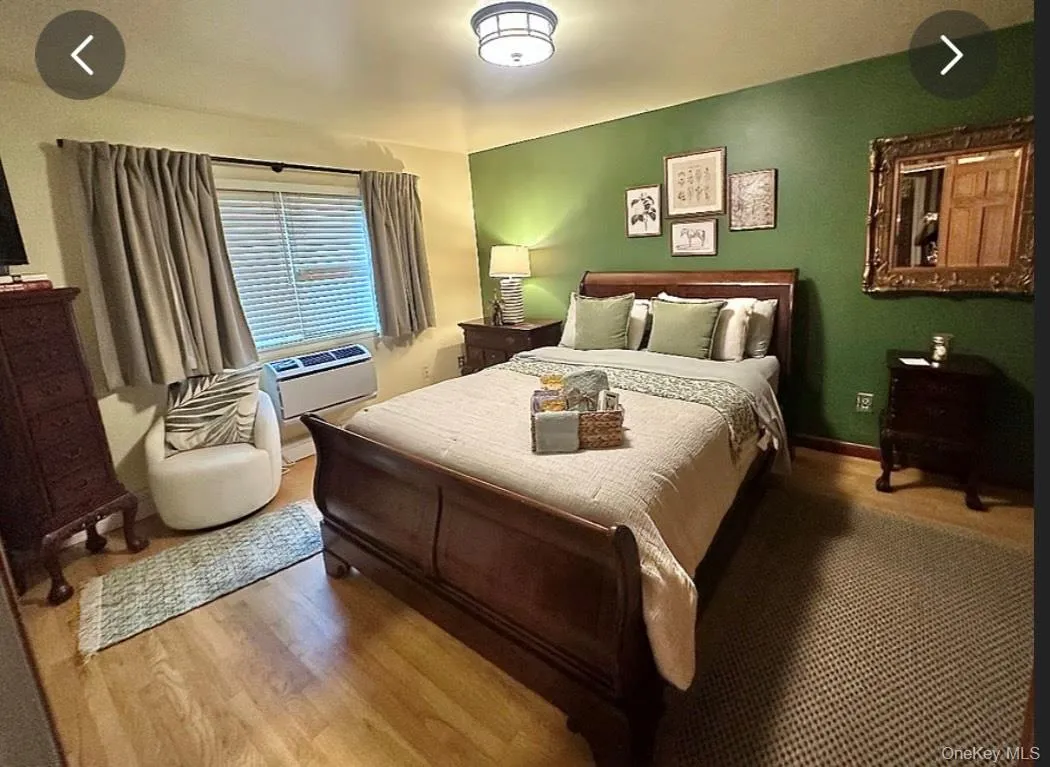 Bedroom with wood finished floors and cooling unit Bedroom with wood finished floors and cooling unit
