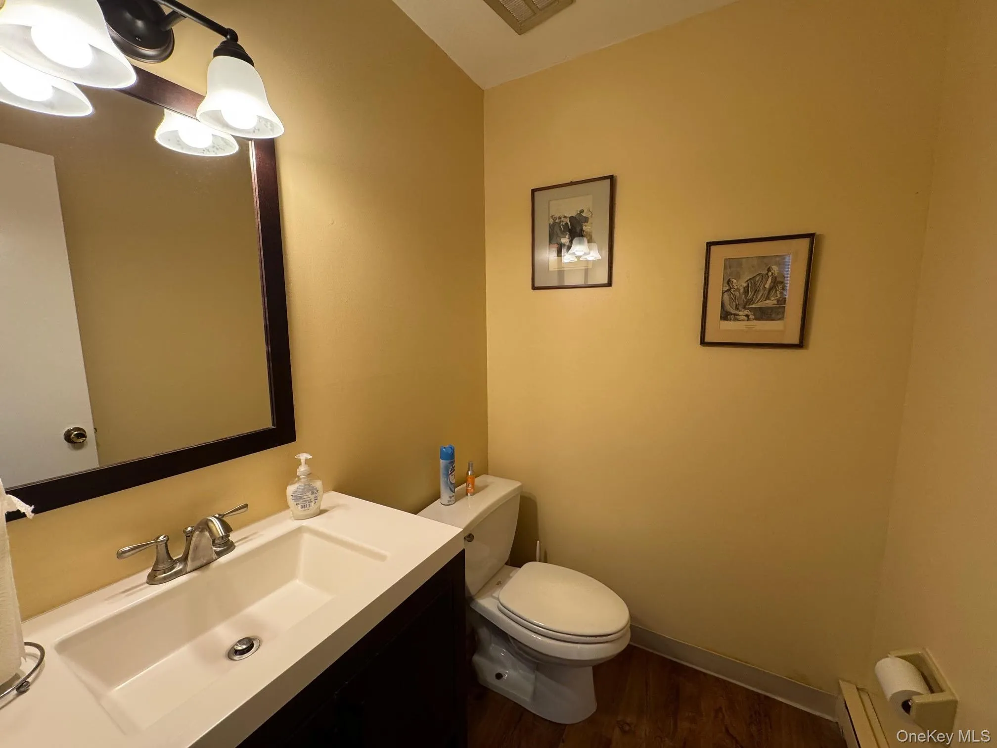 Half bath featuring vanity, dark wood-style flooring Half bath featuring vanity, dark wood-style flooring