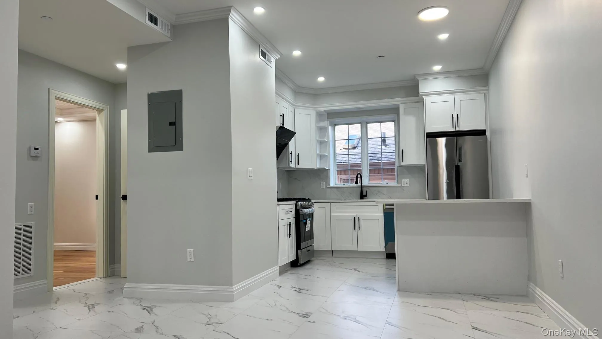 Kitchen with light marble finish floors, white cabinetry, appliances with stainless steel finishes, tasteful backsplash, and recessed lighting Kitchen with light marble finish floors, white cabinetry, appliances with stainless steel finishes, tasteful backsplash, and recessed lighting