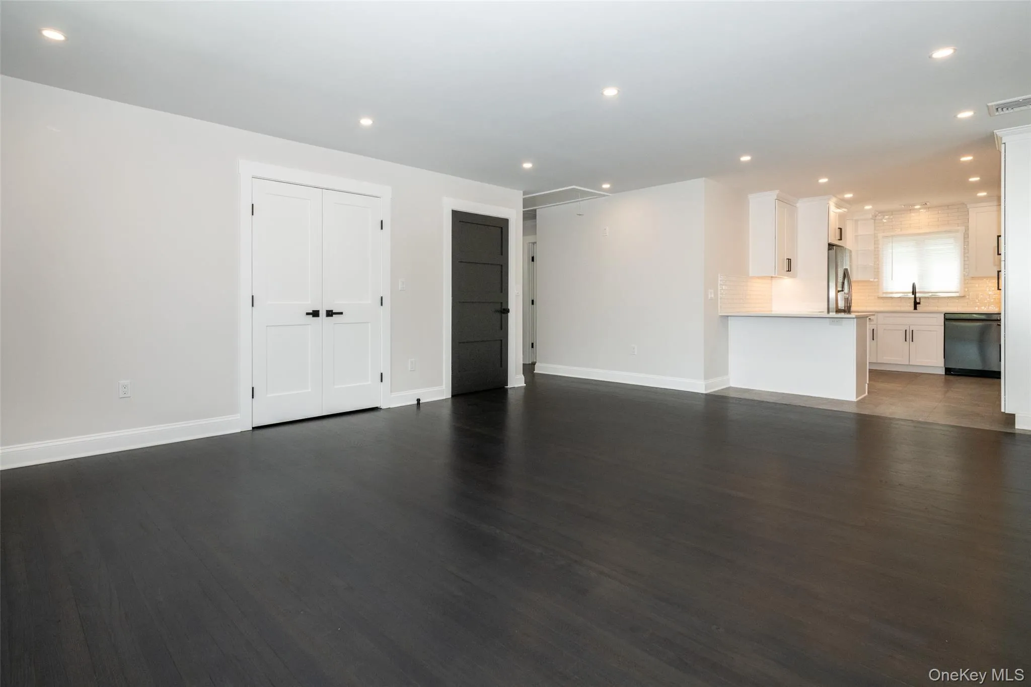 Unfurnished living room with recessed lighting and dark wood-style flooring Unfurnished living room with recessed lighting and dark wood-style flooring