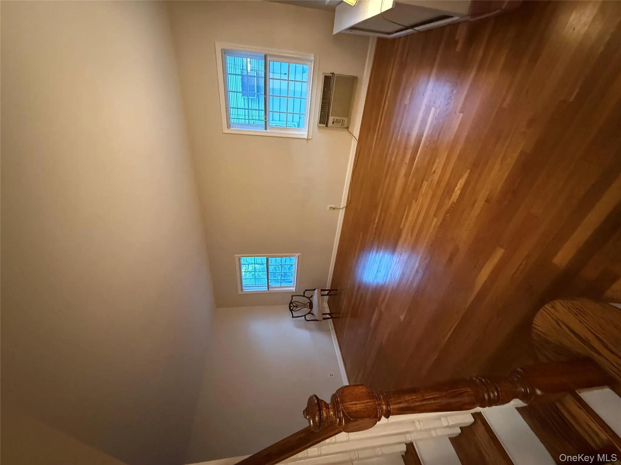 Unfurnished living room with dark wood finished floors and stairway Unfurnished living room with dark wood finished floors and stairway