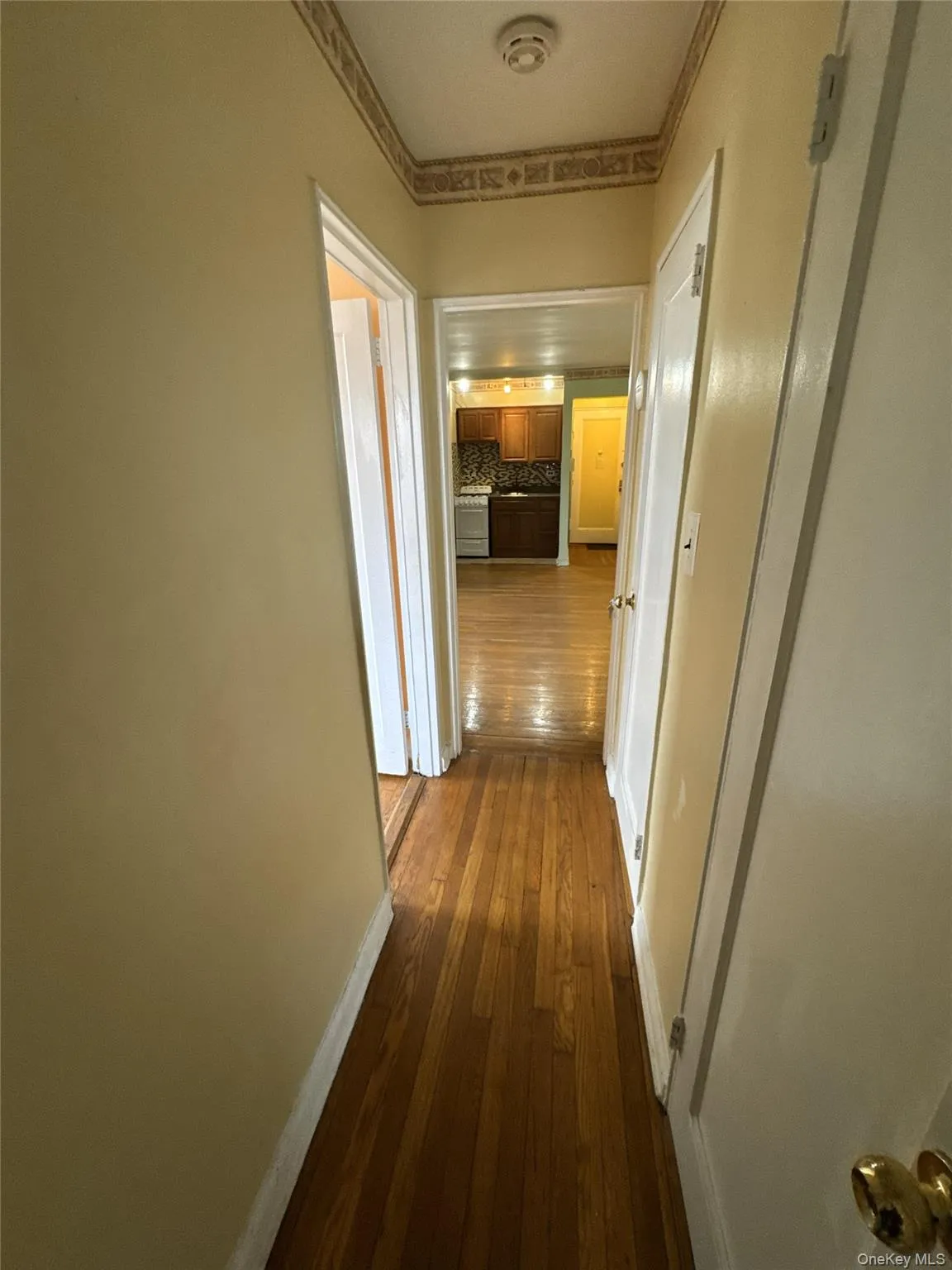 Hall with dark wood-type flooring and ornamental molding Hall with dark wood-type flooring and ornamental molding