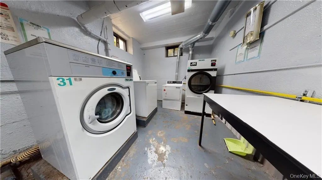 Community laundry with a textured wall and washing machine and clothes dryer Community laundry with a textured wall and washing machine and clothes dryer