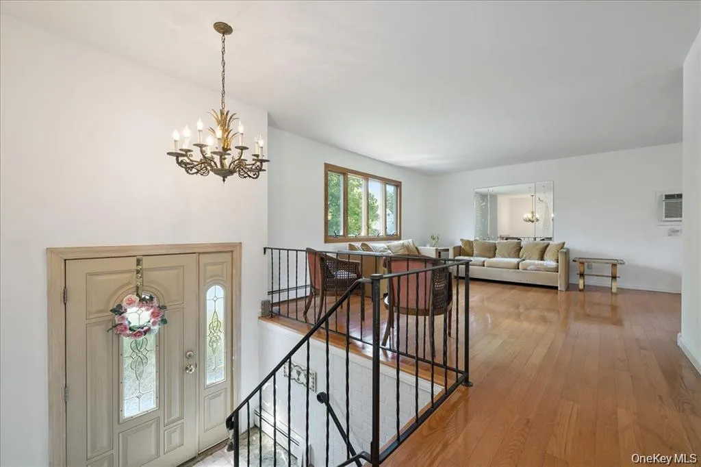 Entryway with a chandelier, light wood-type flooring, a baseboard radiator, and a wall mounted air conditioner Entryway with a chandelier, light wood-type flooring, a baseboard radiator, and a wall mounted air conditioner