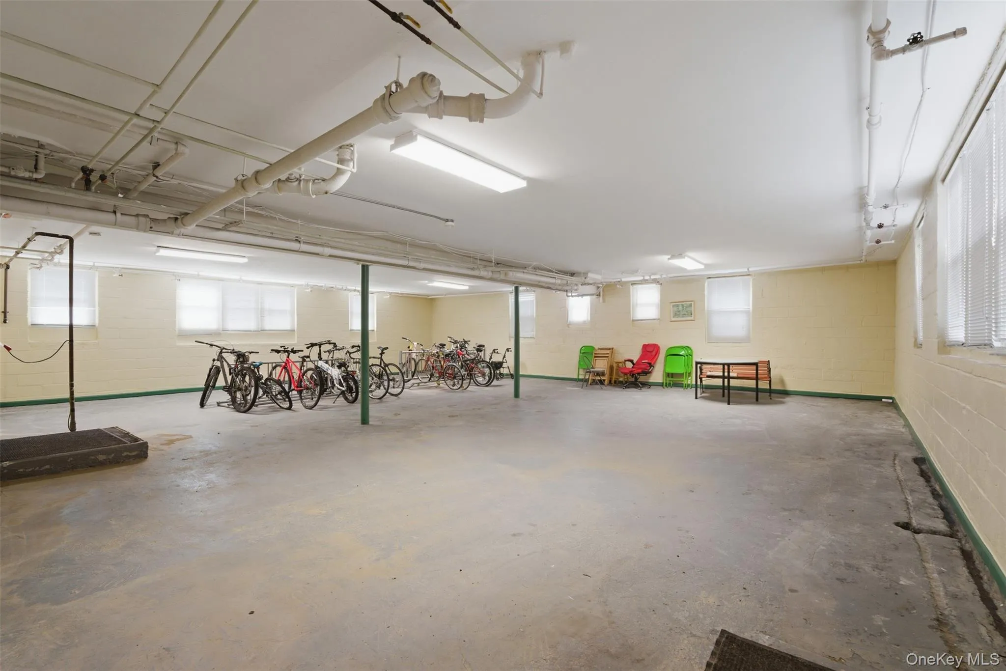Spacious basement utility area with several windows and bicycle racks. Spacious basement utility area with several windows and bicycle racks.