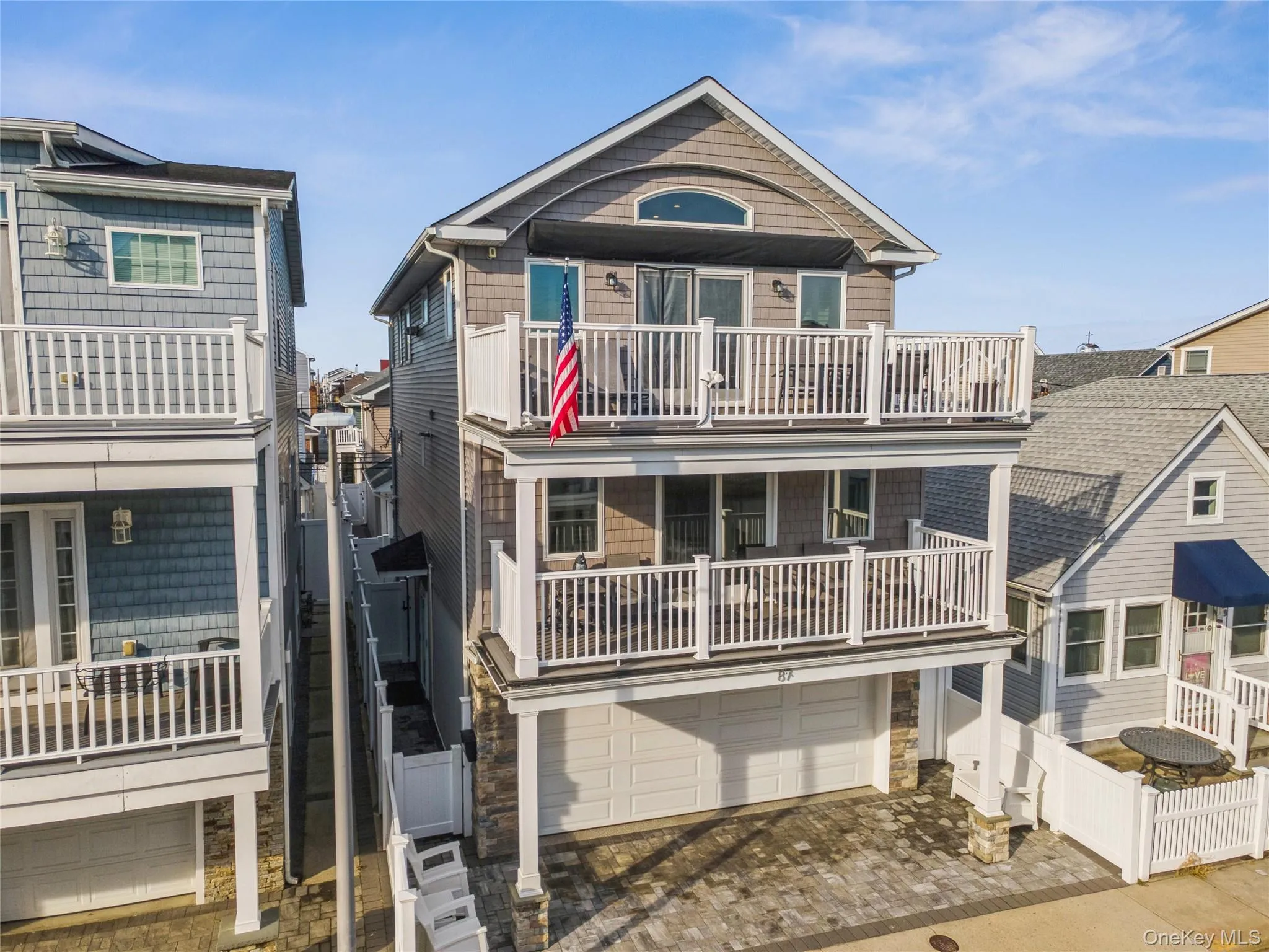 View of front of home with a balcony, driveway, a garage, and stone siding View of front of home with a balcony, driveway, a garage, and stone siding