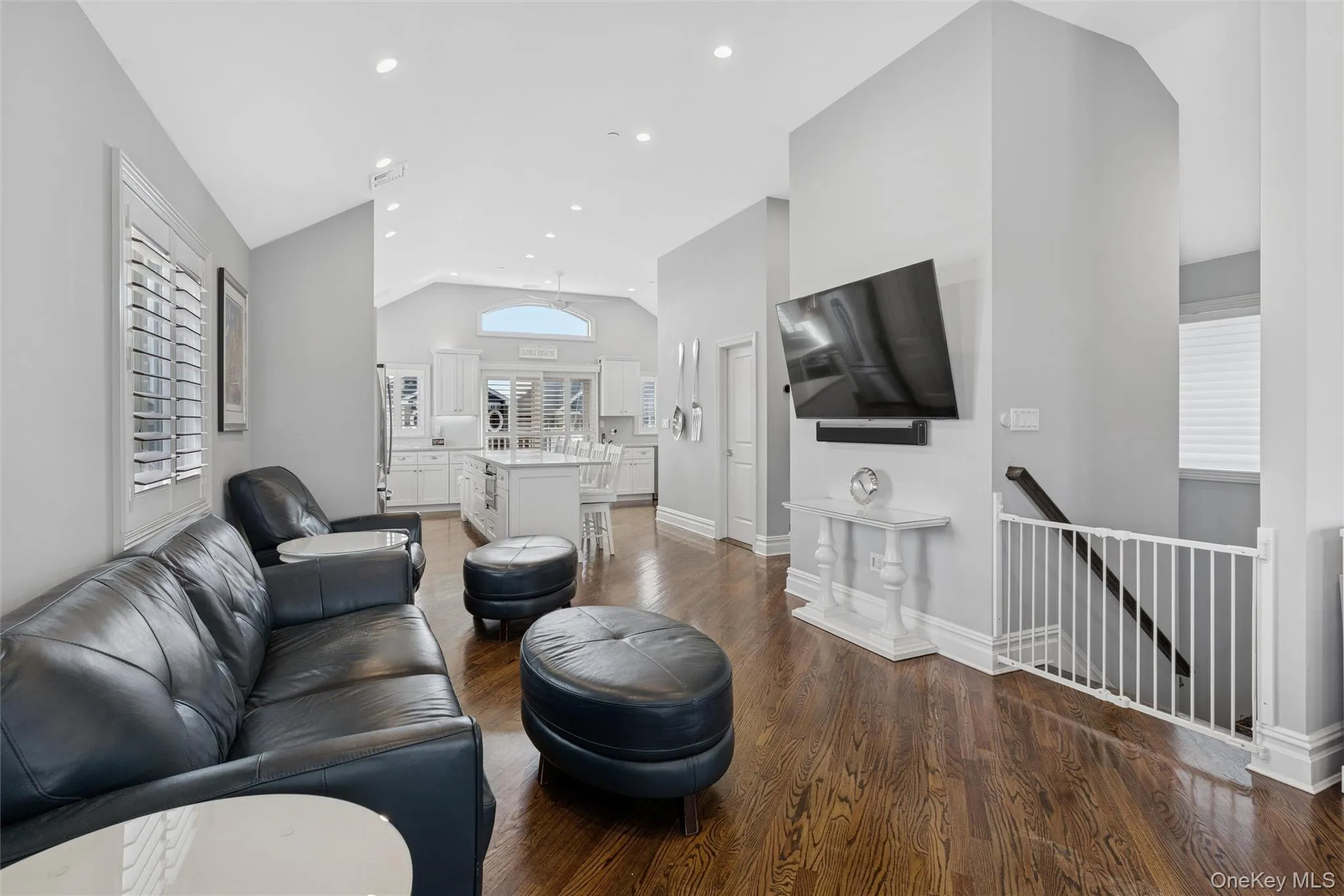 Living area featuring dark wood-style flooring, recessed lighting, and high vaulted ceiling Living area featuring dark wood-style flooring, recessed lighting, and high vaulted ceiling