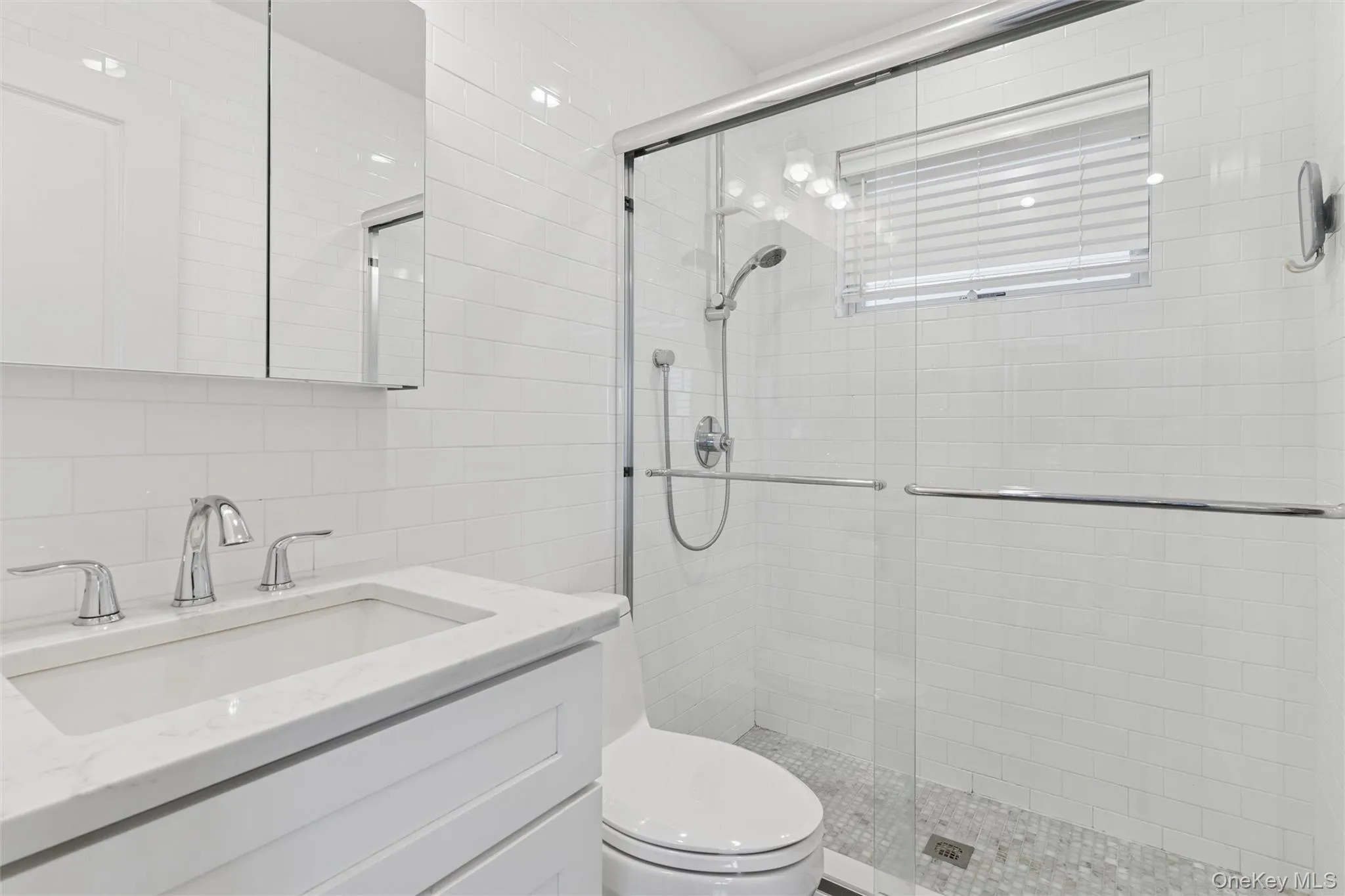Full bath featuring tile walls, vanity, a stall shower, and backsplash Full bath featuring tile walls, vanity, a stall shower, and backsplash