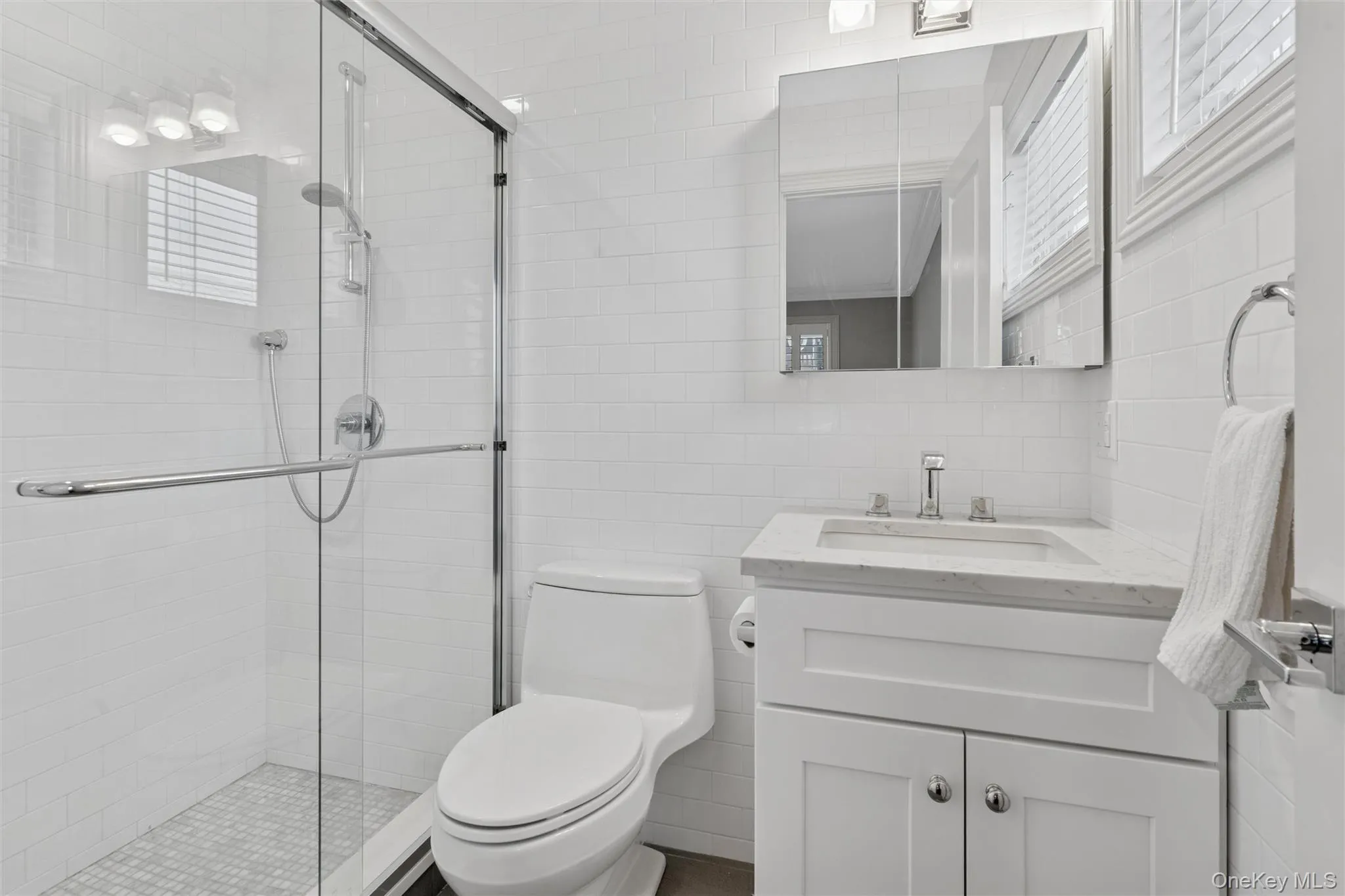 Bathroom featuring tile walls, vanity, and a stall shower Bathroom featuring tile walls, vanity, and a stall shower