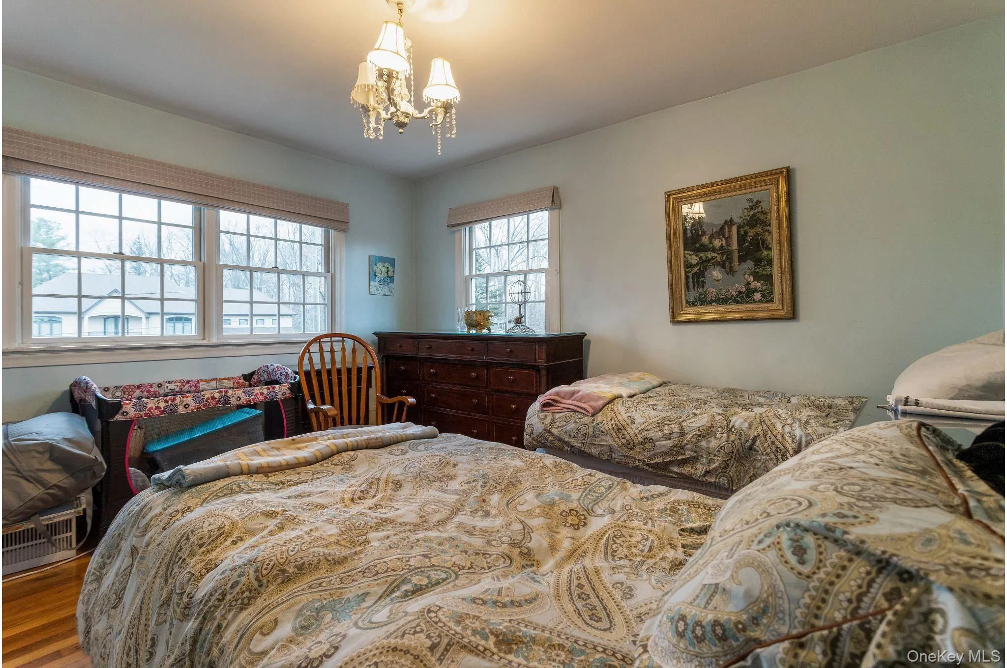 Bedroom with a chandelier and wood finished floors Bedroom with a chandelier and wood finished floors