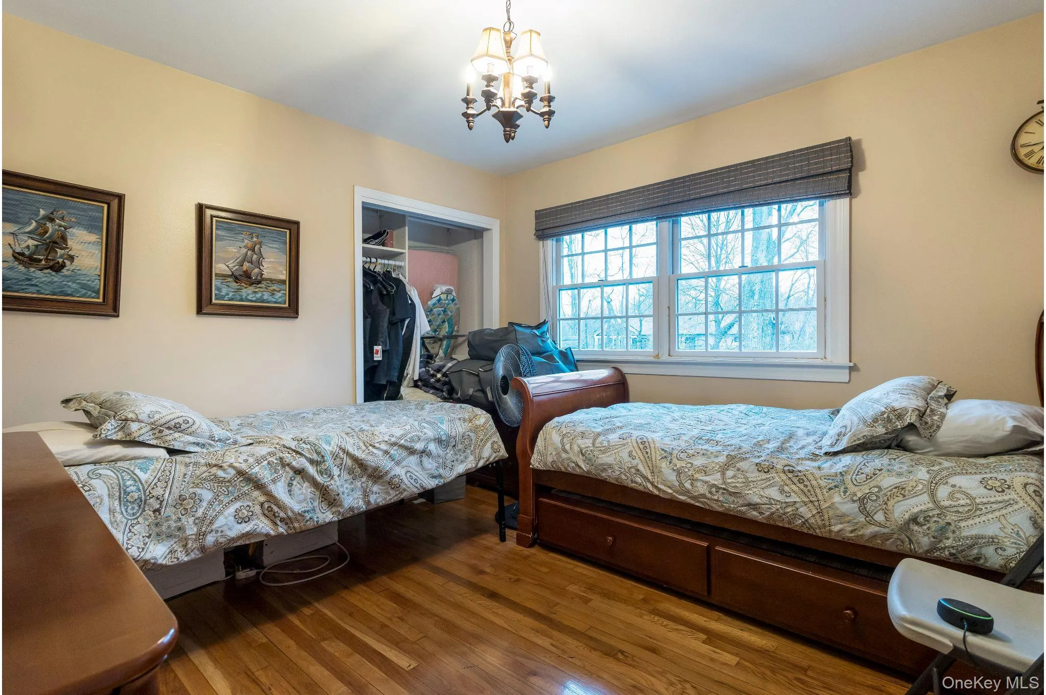 Bedroom featuring wood finished floors, a closet, and a chandelier Bedroom featuring wood finished floors, a closet, and a chandelier